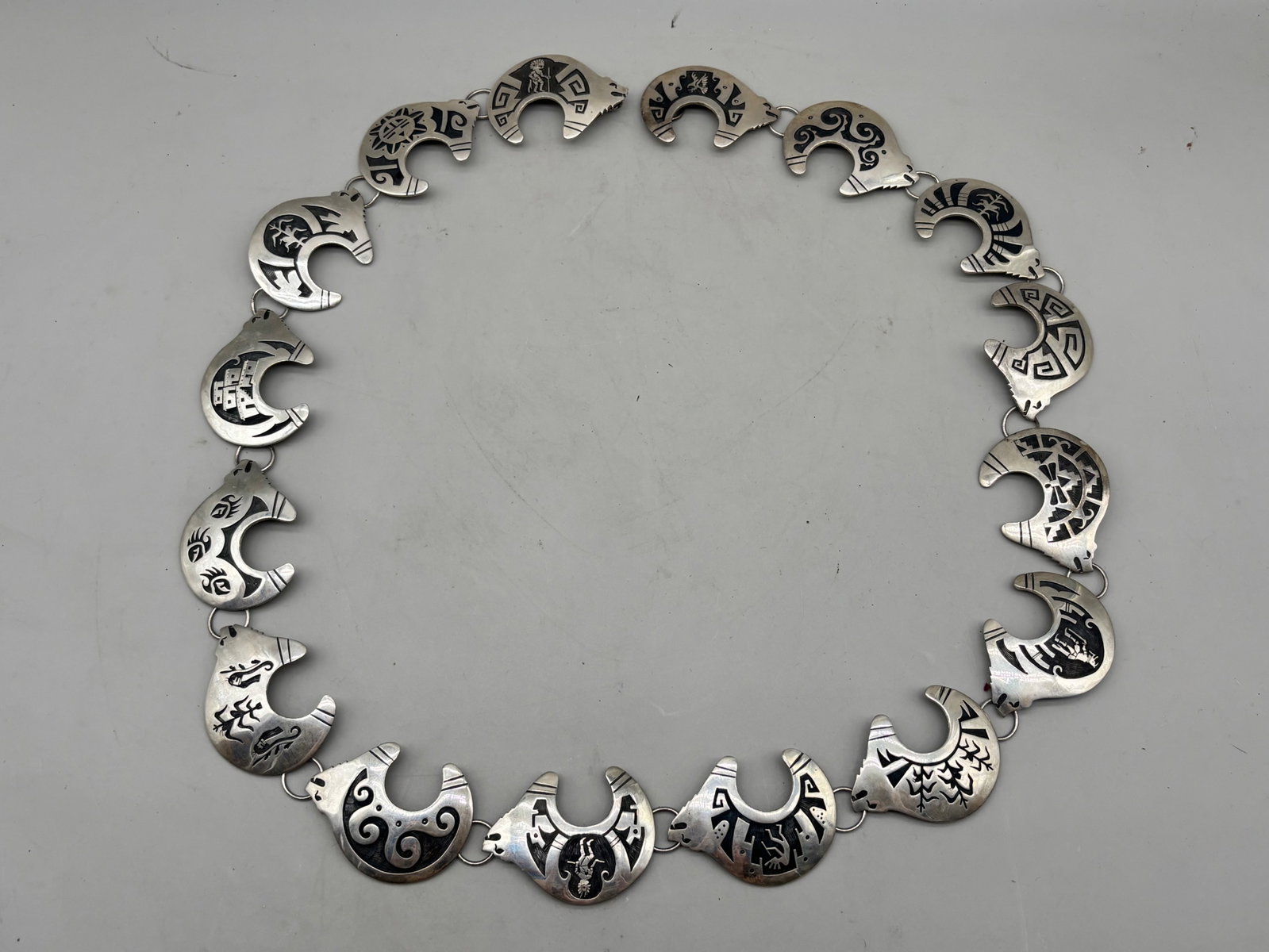 Navajo Sterling Bear Link Concho Belt: A Navajo sterling silver concho belt with bear-form links and etched geometric and stylized element designs. Hallmarked and marked Sterling. 12.76 ozt. 2in tall x 40in long. | You have additional