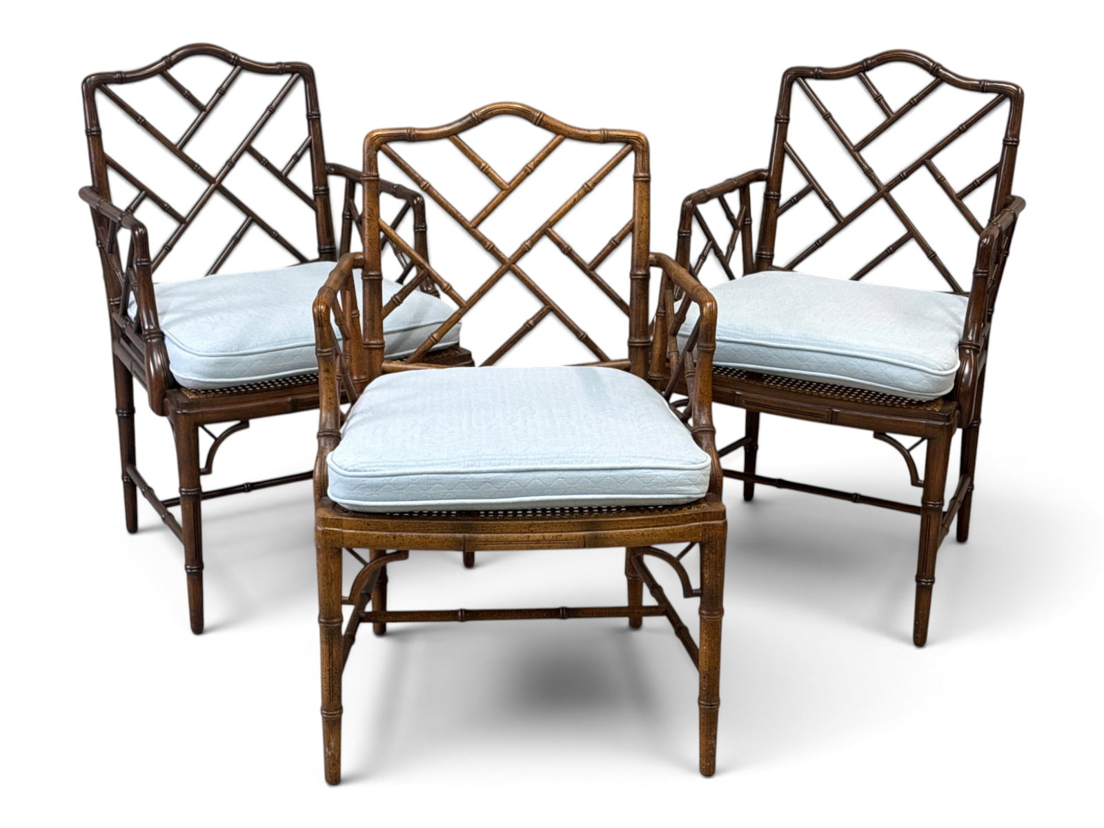 Three Chinese Chippendale Faux-Bamboo Open Armchairs: Three Chinese Chippendale faux-bamboo open-arm chairs with caned seats and upholstered cushions. Includes a pair plus one with a similar finish. 35-1/2in tall x 23in wide x 19in deep. | You have