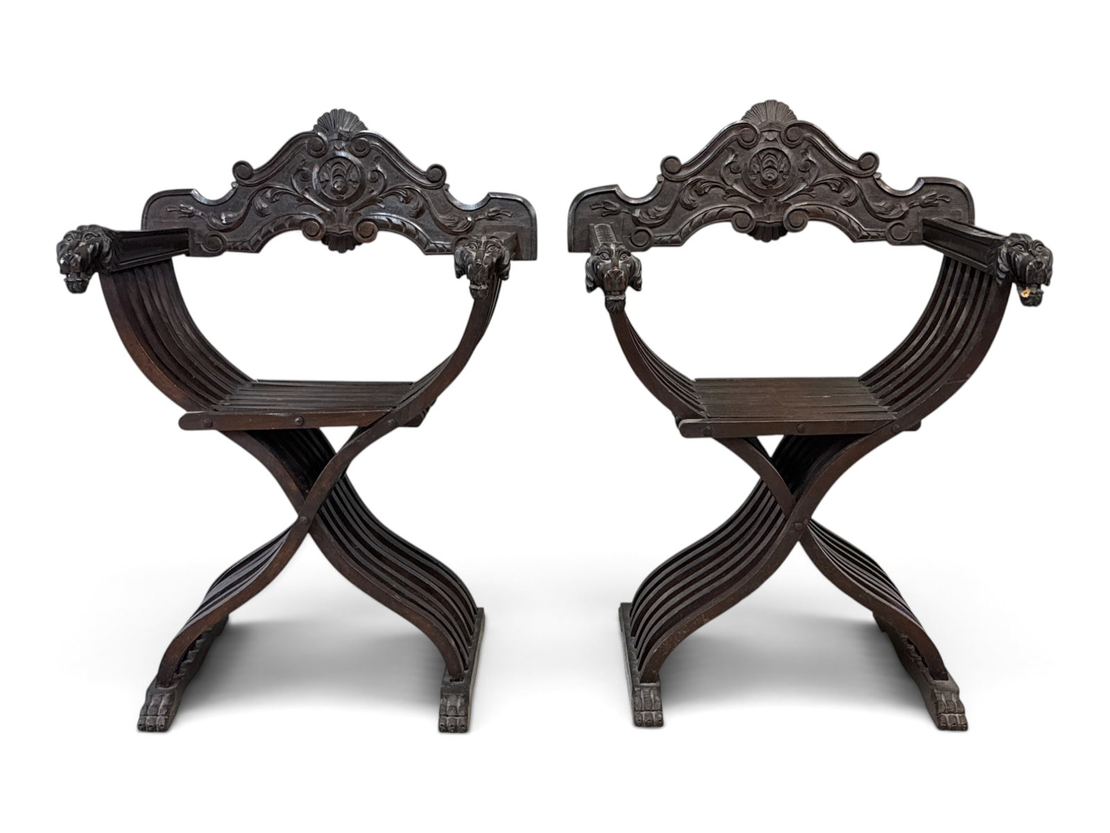 Pair of Italian Renaissance Revival Savonarola Chairs: A pair of Italian Renaissance Revival Savonarola chairs with carved backs and lion mask handles. 35-1/2in tall x 27in wide x 21-1/2in deep. | You have additional shipping options, and are not required