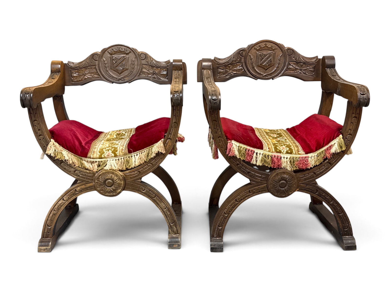 Pair of Italian Renaissance Revival Savonarola Chairs: Pair of Italian Renaissance Revival savonarola chairs with armorial crest carved backs. 31in tall x 24-1/2in wide x 20-1/4in deep. | You have additional shipping options, and are not required to use L