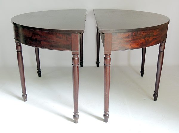 Pair of George III Pier Tables: Pair of English George III mahogany demilune pier tables on turned legs. Each: 29" tall, 52-1/2" wide, 24" deep.