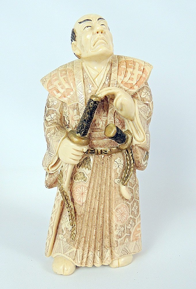 Antique Chinese Carved and Painted Ivory: Antique Chinese carved and painted ivory robed man holding a ceremonial sword, with a red, black, and gold coloring. 9" tall.