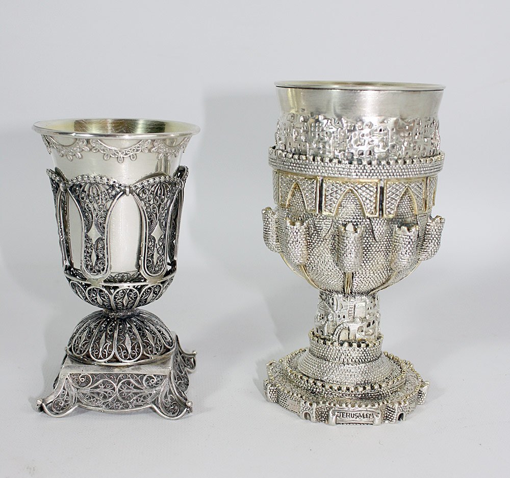Two Sterling Footed Cups: Two sterling footed cups: One featuring a relief decorated scene of Jerusalem (5-3/4" tall), the other a finely pierced base with a scrolled decoration, holding a removable sterling silver cup (5" tal