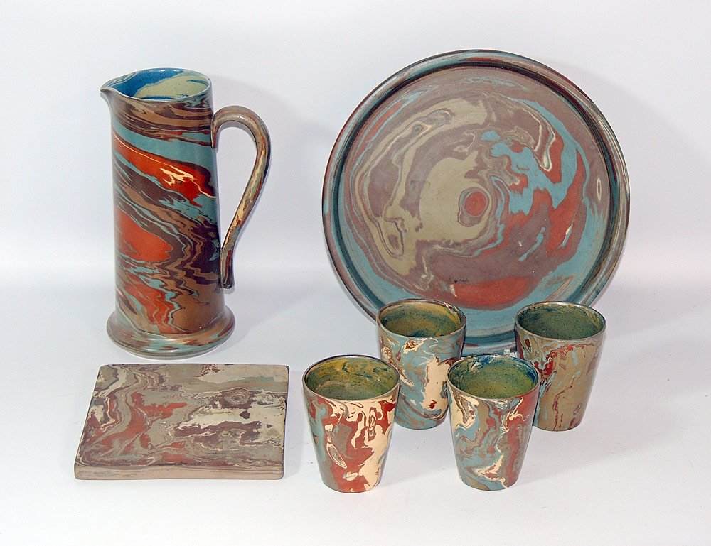 Niloak Missionware Grouping: Grouping to include pitcher; four tumblers; round platter; unmarked trivet. Pitcher: 10" tall. Tumblers: 3-3/4" tall. Platter: 11" diameter.