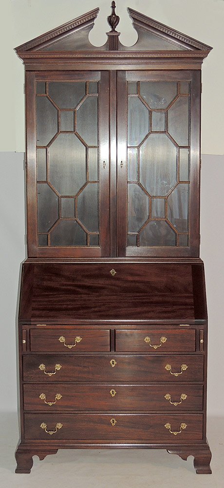 Stickley Mahogany Secretary Desk: Chippendale style mahogany, with broken pediment top. Lighted display cabinet with two glass shelves, over a case holding a fall front desk with fitted interior and two-over-three drawer arrangement. 