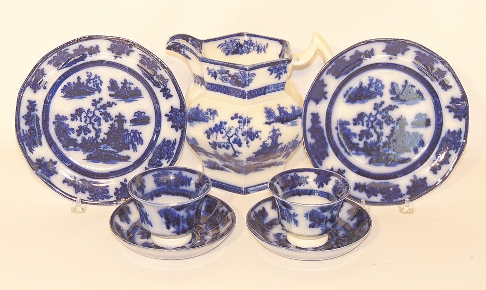Collection of Flow Blue Chapoo Pattern Ironstone: Grouping to include: pitcher, two dessert plates, two cups with saucers. Pitcher: 8" tall.