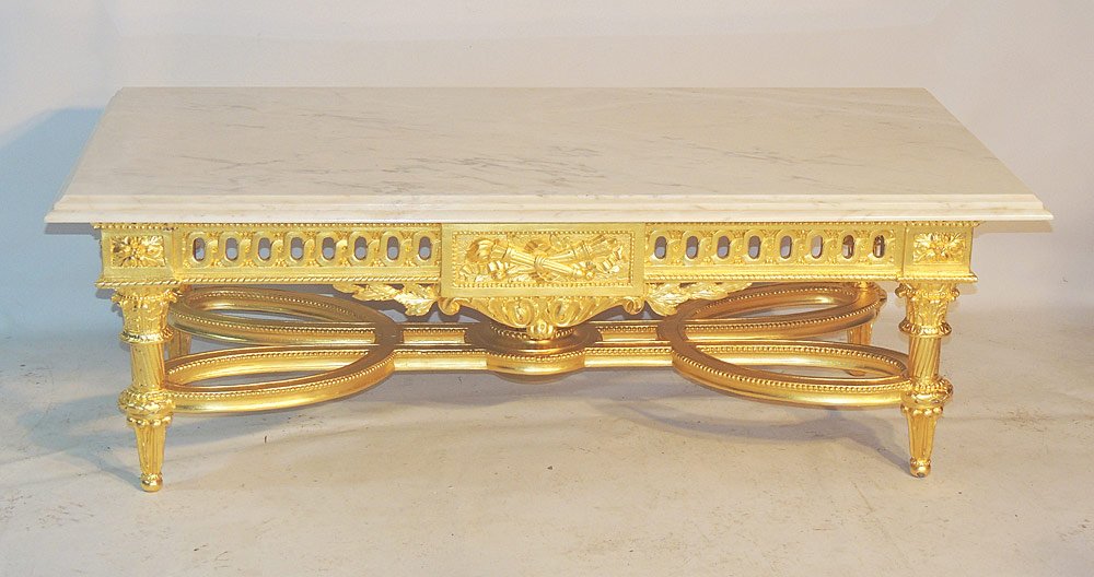Louis XVI Style Coffee Table: Louis XVI style coffee table. 20th Century. With a molded white marble rectangular top over a carved gilt wood base. 20" tall x 57" long x 28" wide. Provenance: From a prominent Centreville, DE Estate
