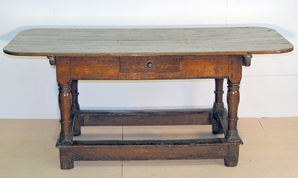 English Oak Tavern Table: English oak tavern table. With overhanging rectangular top over a pegged base with turned legs and stretchers. Single drawer. 29" tall x 66" wide x 29-1/2" deep. Provenance: From the Estate of Albert