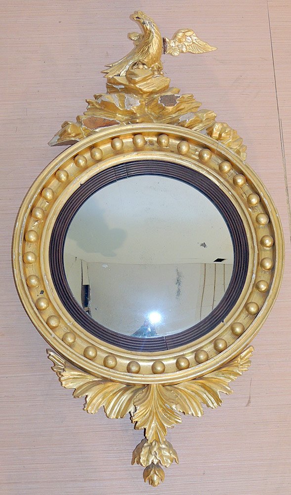 Regency Giltwood Convex Mirror: Regency giltwood convex mirror. Round frame and reeded bezel. Crested by spread-winged eagle. Leaf form pendant below. 19th century. 38-1/2" long x 22" wide. Provenance: From the Estate of Albert M. a