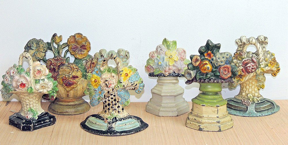 Six Cast Iron Flower Basket Doorstops: Assembled grouping of six cast iron flower basket doorstops. Tallest: 6-1/2 in.