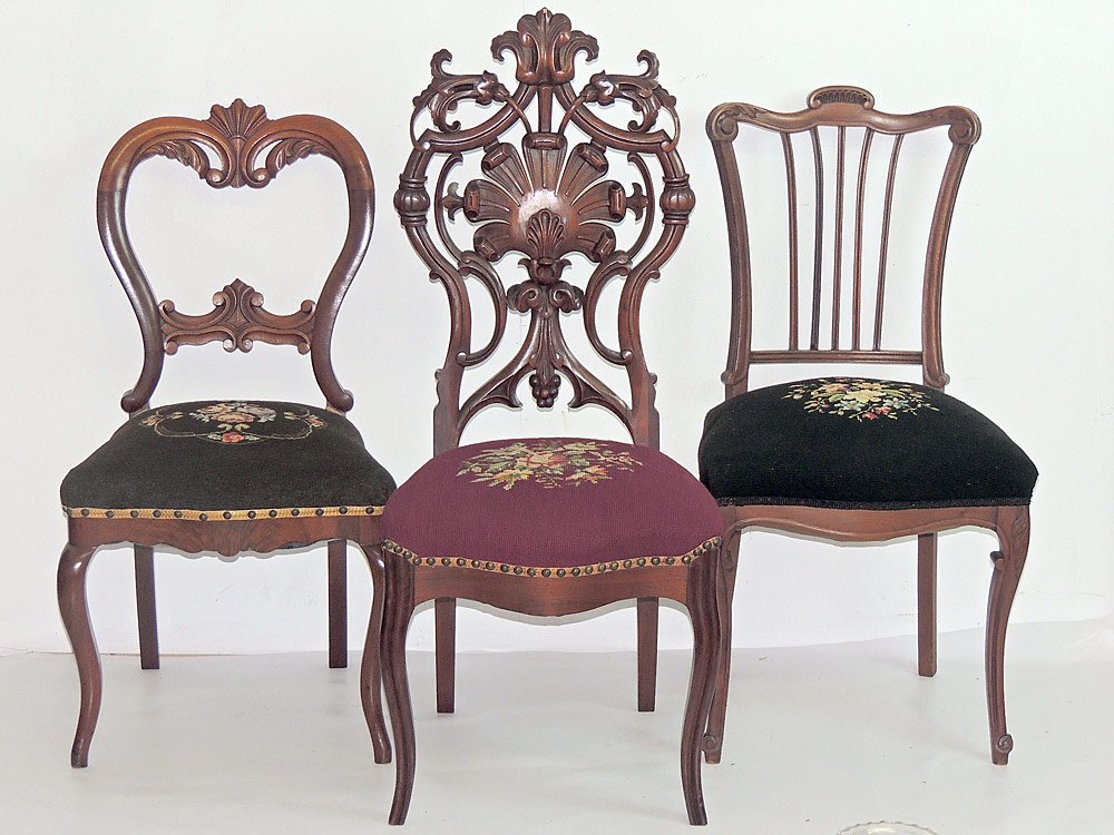 Three Victorian Side Chairs: A grouping of three Victorian carved side chairs, each with needlepoint seats. Tallest: 41-1/2 in.