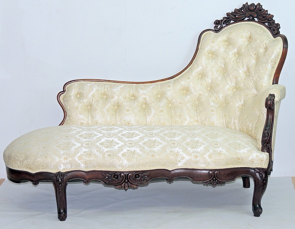 Victorian Mahogany Fainting Couch: Victorian mahogany fainting couch with carved crest on backrail, and damask upholstery. 43 x 59 x 31 in.