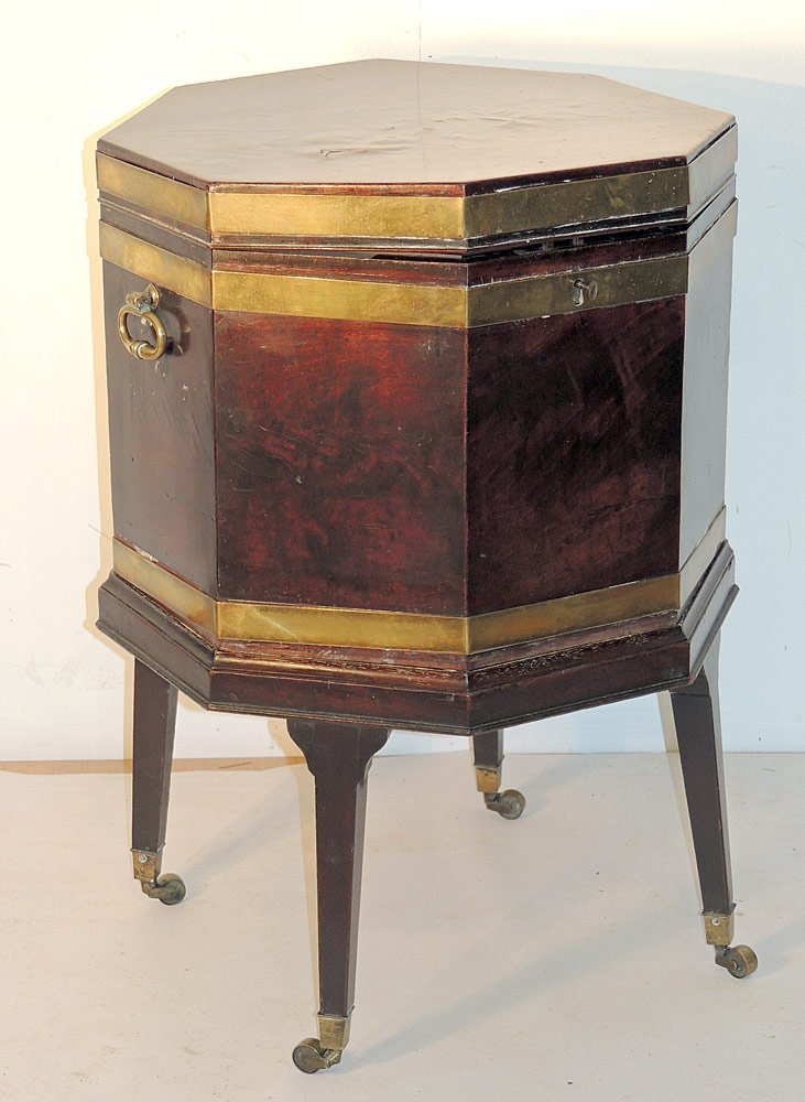 English Mahogany Wine Cellarette: English mahogany wine cellarette. 19th Century. Octagonal brass bound case on stand with tapering square legs and casters. Height: 29 in. Width: 19 in.