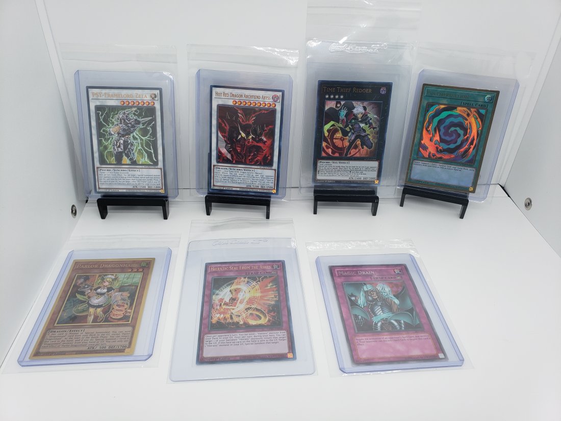(7) TCG Yugioh Mago, GFTP, PSV, MGED: * 7 various Yugioh cards from different sets and years. * All these cards say 1st edition besides Magic Drain trap card.* As you see various cards of spell cards, trap cards, and the actual fighter ca