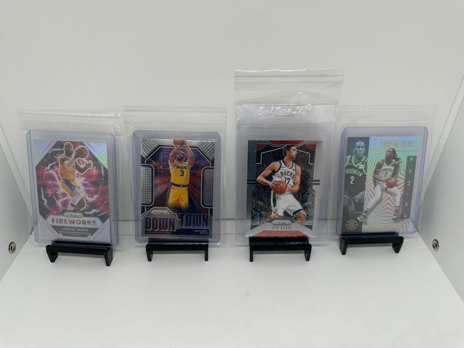 LeBron James Silver, Davis & Gasol Lakers: Los Angeles Lakers NBA Basketball lotLeBron James fireworks Silver PrizmAnthony Davis Downtown PrizmPau Gasol ( Bucks jersey) PrizmTaurean Prince ( Nets jersey)