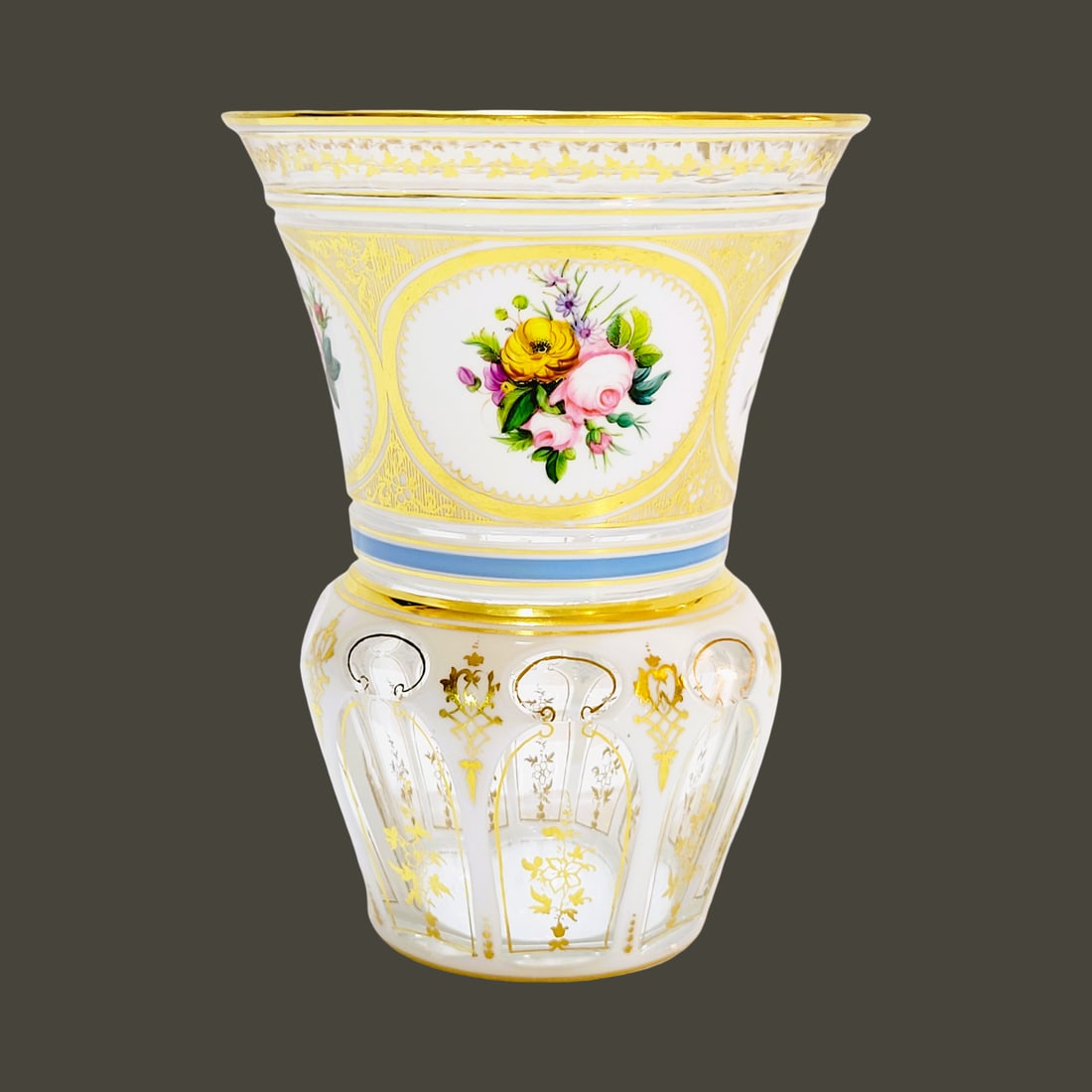 Neuwelt Glass Beaker, Bohemian Glass Beaker, Floral Beaker, possibly by Wilhelm Hoffmann: 5.0" Tall by 3 3/4" Wide blown colorless glass with a white glass overlay, flared gilded beveled rim with gold floral drapery to a tapered and bulbous tapered base, body with 5 oval hand enameled flor