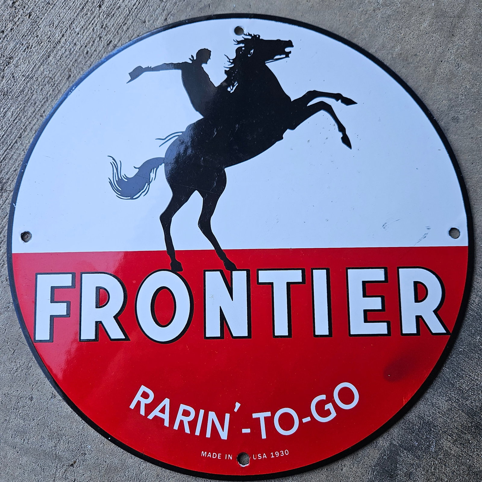 VINTAGE PORCELAIN SIGN - FRONTIER RARIN' TO-GO 1930 COWBOY GRAPHIC: Immerse yourself in the daring dynamism of the old west with this strikingly bold vintage porcelain sign, featuring an iconic cowboy silhouette masterfully captured in the throes of a wild ride atop a