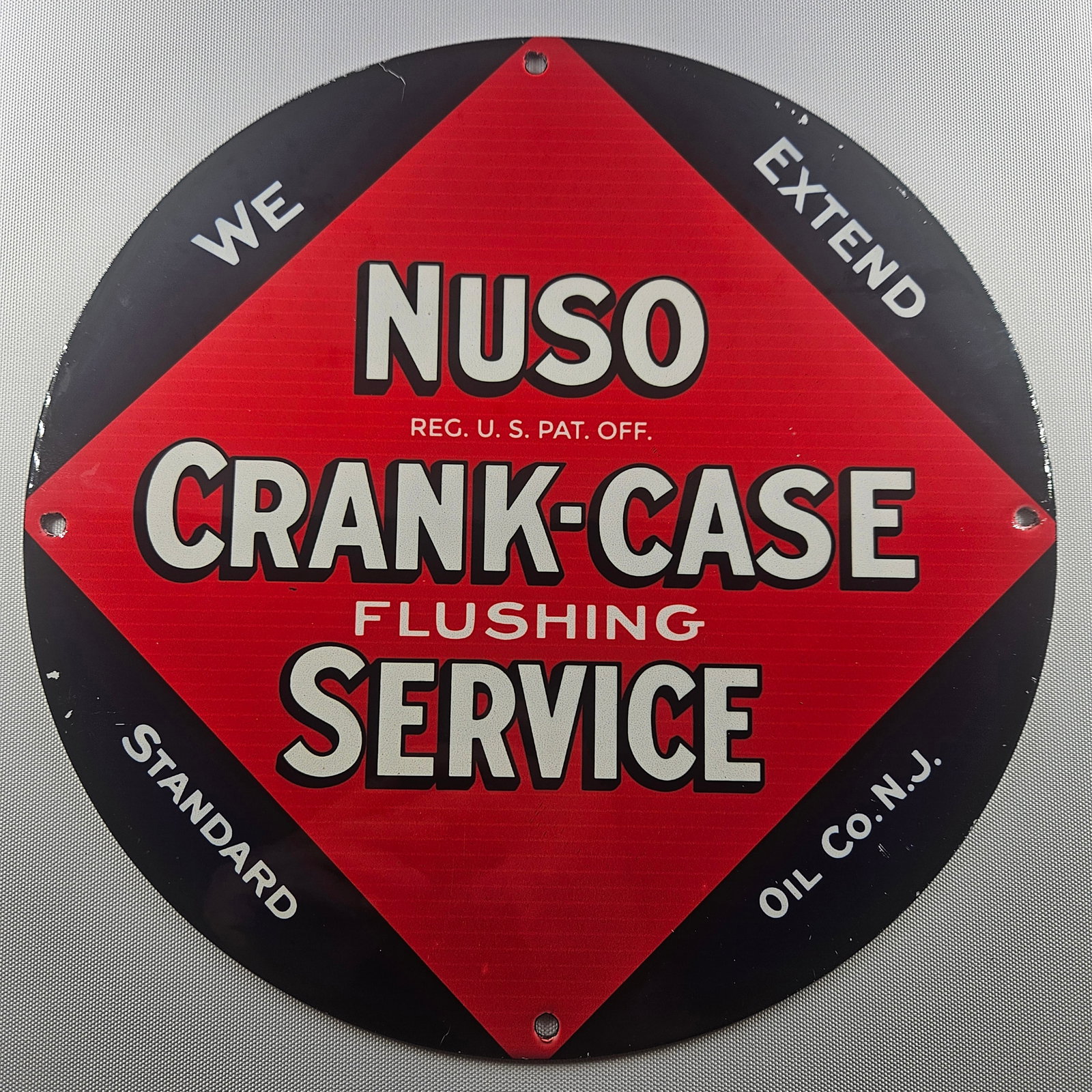 Nuso Crank-Case Flushing Service 12-inch Porcelain Sign: This 12-inch porcelain sign is a captivating piece of advertisement history, showcasing the iconic Bell Helmets brand. The round sign features a striking illustration of a helmeted figure, capturing t