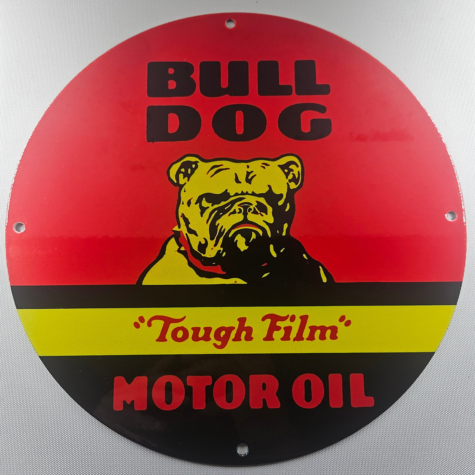 Bull Dog Motor Oil 12-inch Porcelain Sign: The Bull Dog Motor Oil 12-inch Porcelain Sign is a captivating piece of advertisement history, featuring the distinctive Bull Dog Motor Oil logo. Measuring 12 inches in diameter, this sign embodies th