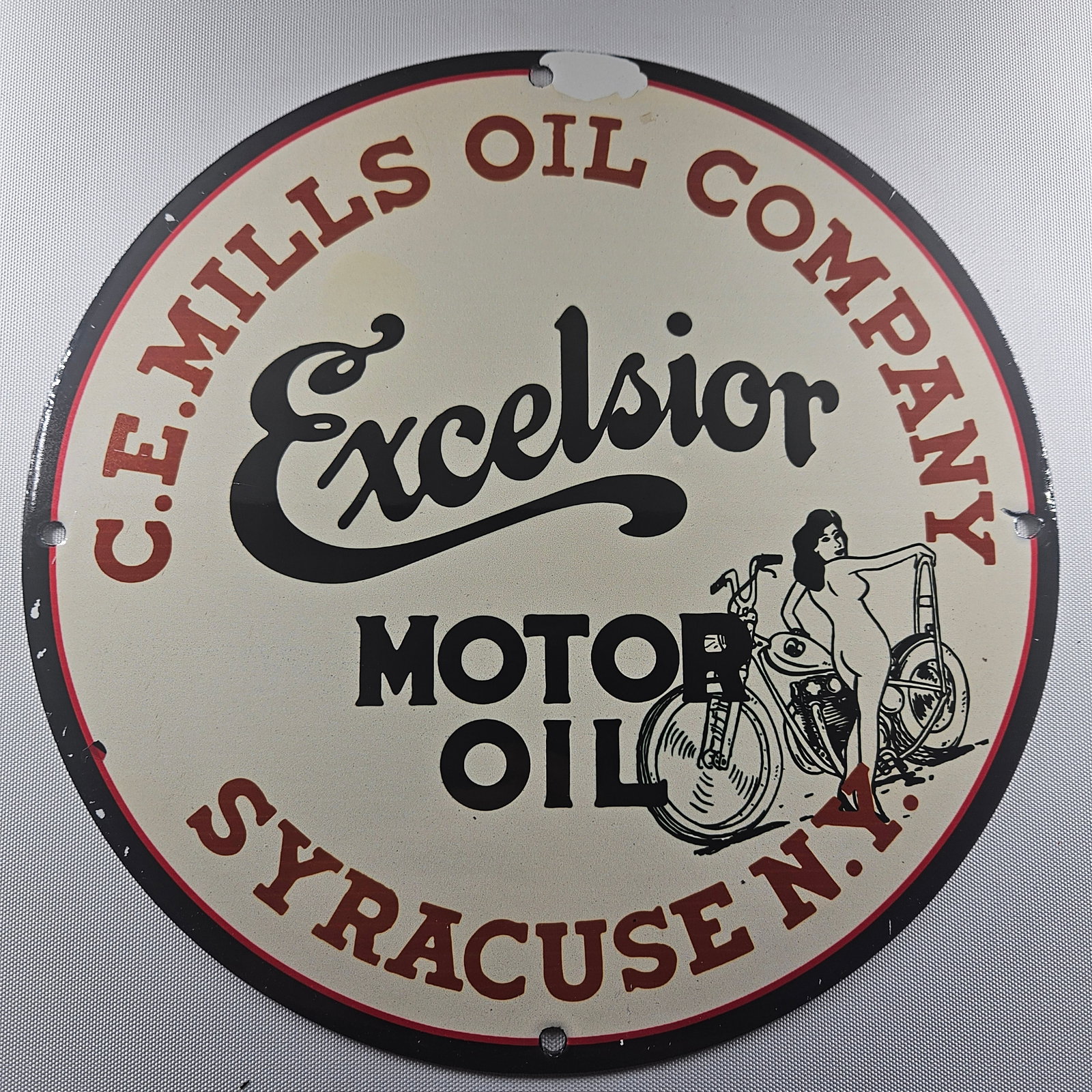 Excelsior Motor Oil 12-inch Porcelain Sign: The Excelsior Motor Oil 12-inch Porcelain Sign is a captivating piece of advertisement history, showcasing the classic Excelsior Motor Oil logo. Measuring 12 inches in diameter, this sign is a testame