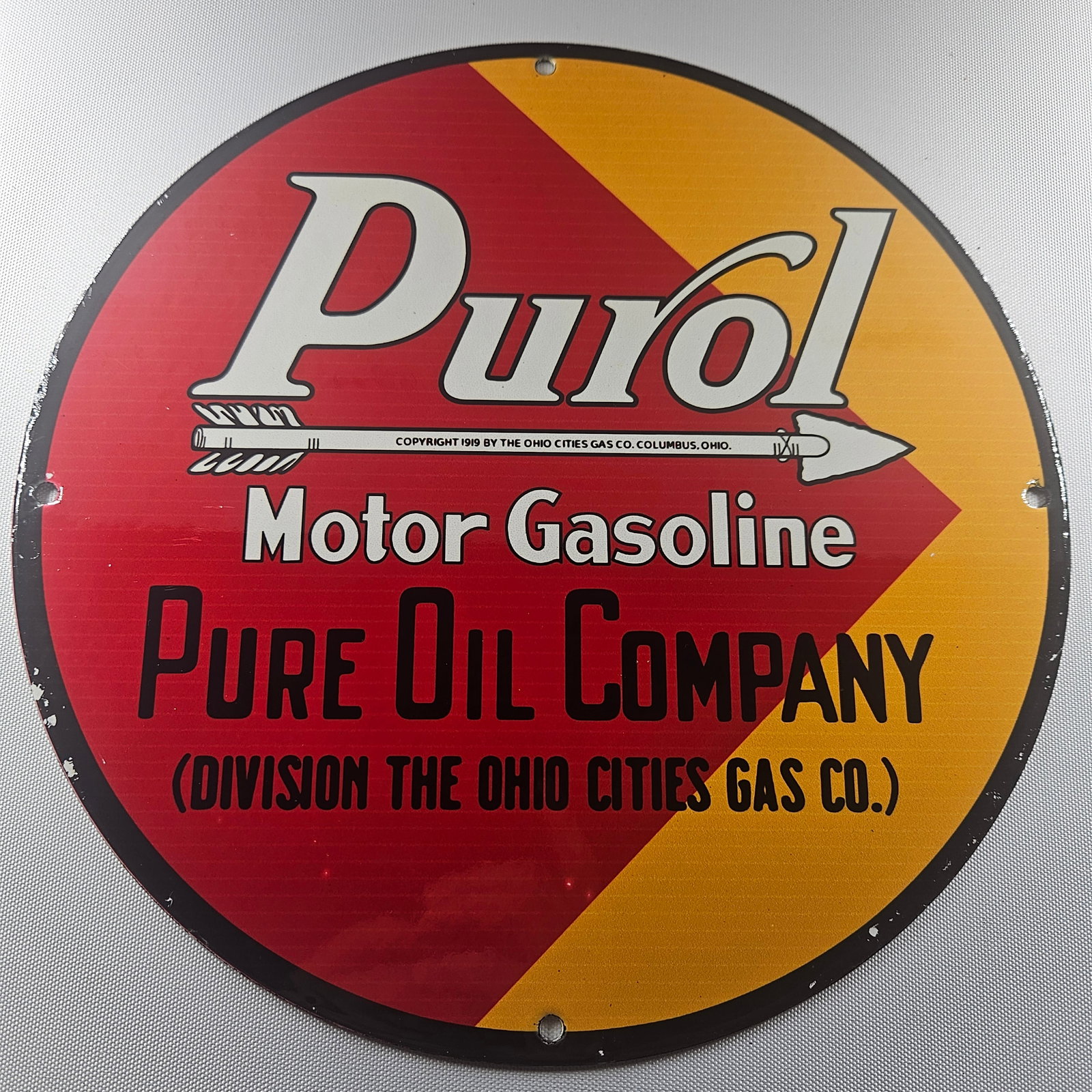 1919 Purol Motor Gasoline 12-inch Porcelain Sign: The 1919 Purol Motor Gasoline 12-inch Porcelain Sign is a fascinating piece of advertisement history, featuring the classic Purol Motor Gasoline logo. Measuring 12 inches in diameter, this sign embodi