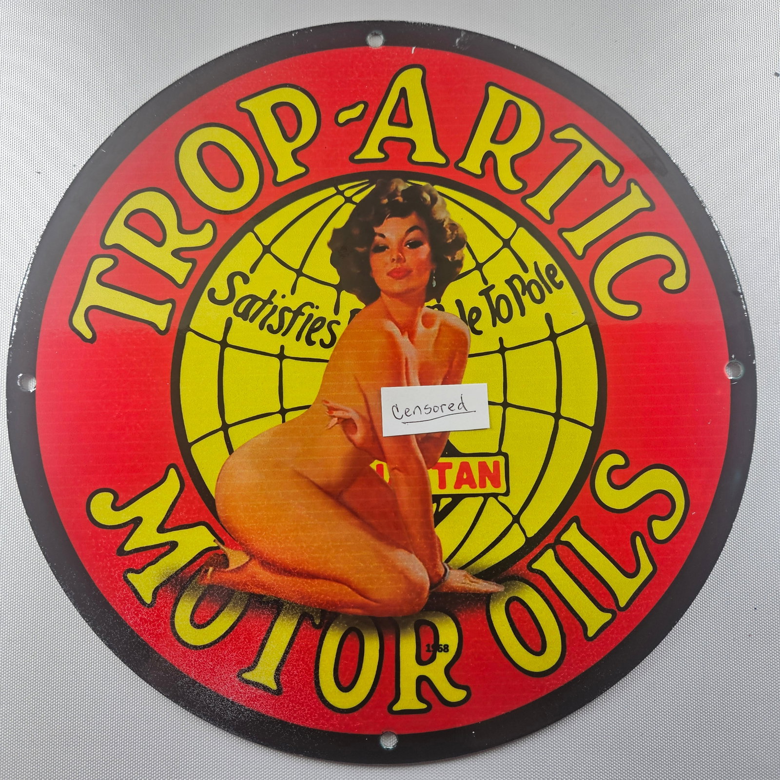 1968 Trop-Artic Motor Oils 12-inch Porcelain Sign: The 1968 Top-Artice Motor Oils 12-inch Porcelain Sign is a fascinating piece of advertisement history, featuring the distinctive logo of Top-Artice Motor Oils. Measuring 12 inches in diameter, this si