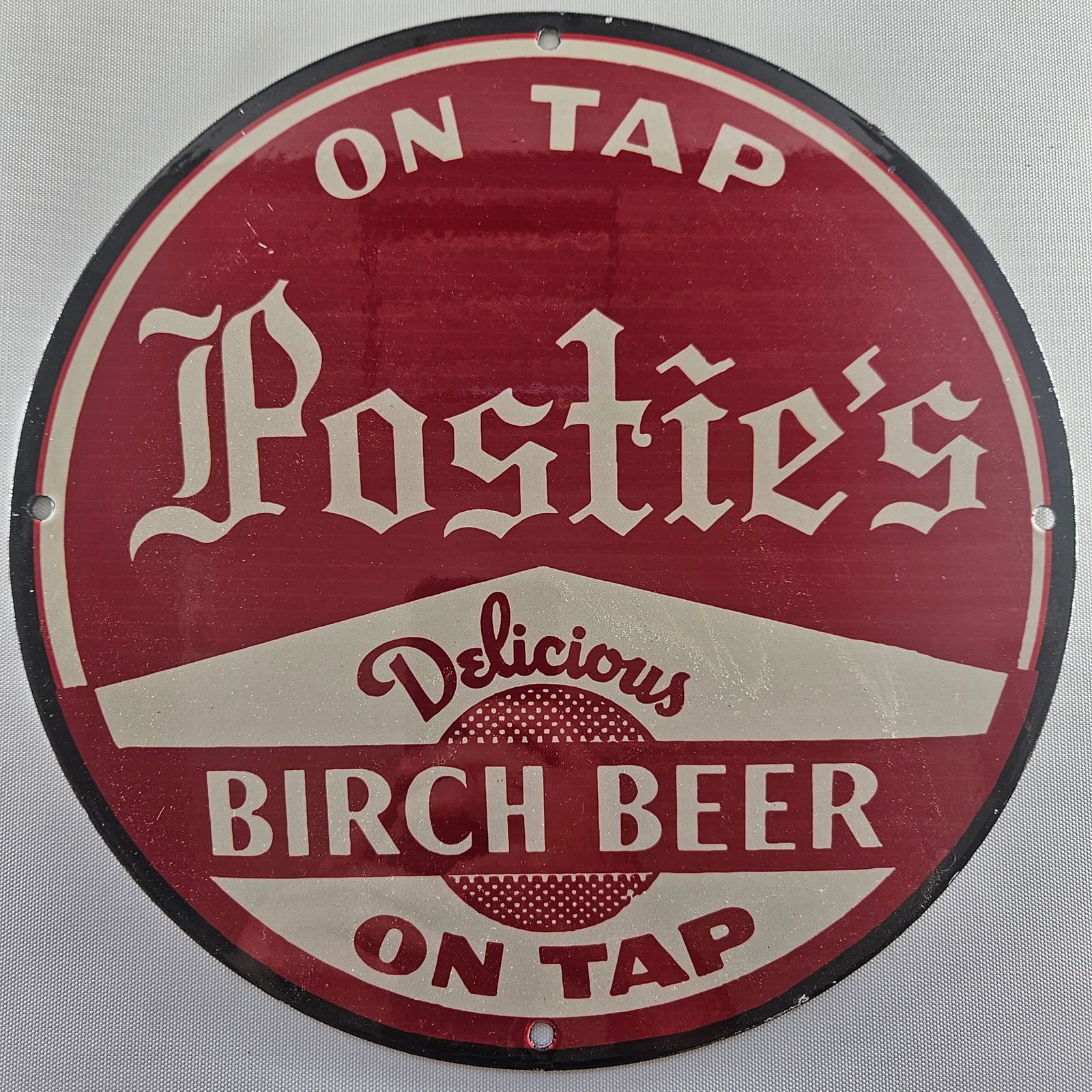 POSTIE'S BIRCH BEER GAS OIL GARAGE MAN CAVE PORCELAIN SIGN: The Postie's Birch Beer advertisement embodies a vibrant slice of advertising history, capturing the essence of early 20th-century branding. Its striking graphics and bold colors serve as a nostalgic