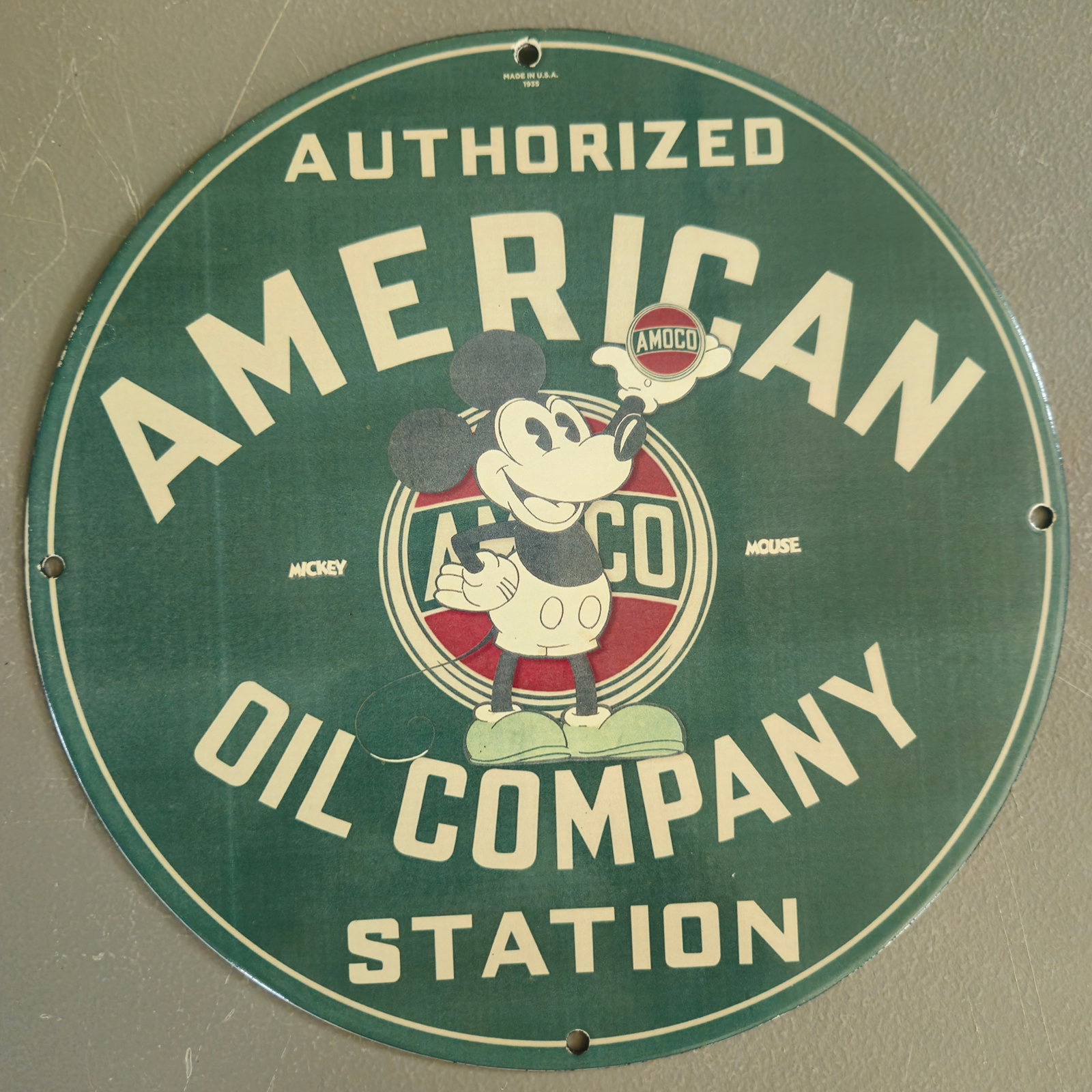 Vintage Porcelain Sign: Authorized American Oil Company Station with Mickey Mouse: This exceptional vintage porcelain sign is a stunning collectible piece that captures the nostalgic essence of the mid-20th century. Measuring approximately 12 inches in diameter, this round sign feat