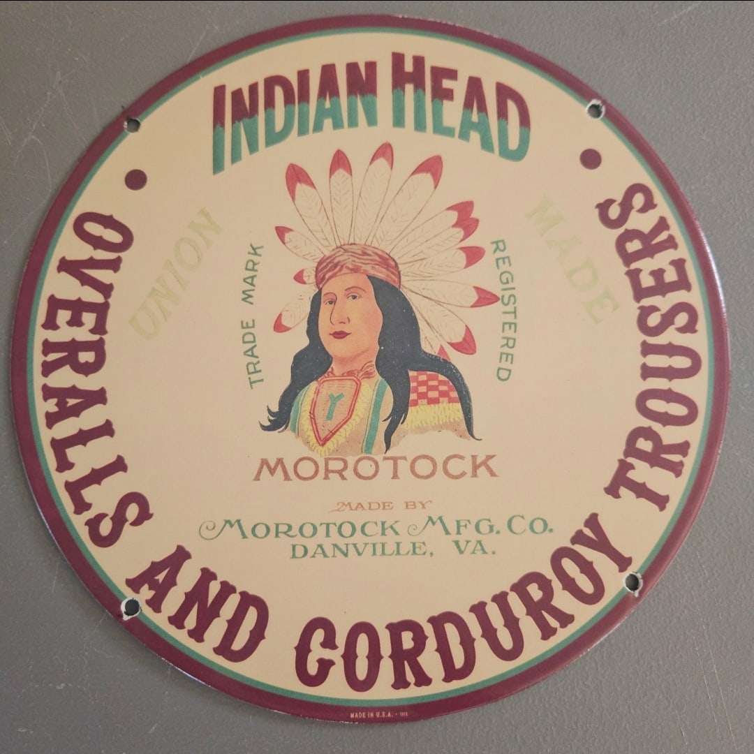 Vintage Indian Head Porcelain Sign for Morotock Overalls and Corduroy Trousers: This stunning vintage porcelain sign showcases the iconic "Indian Head" design, a classic piece of Americana that reflects the rich history of textile manufacturing in the United States. The sign feat