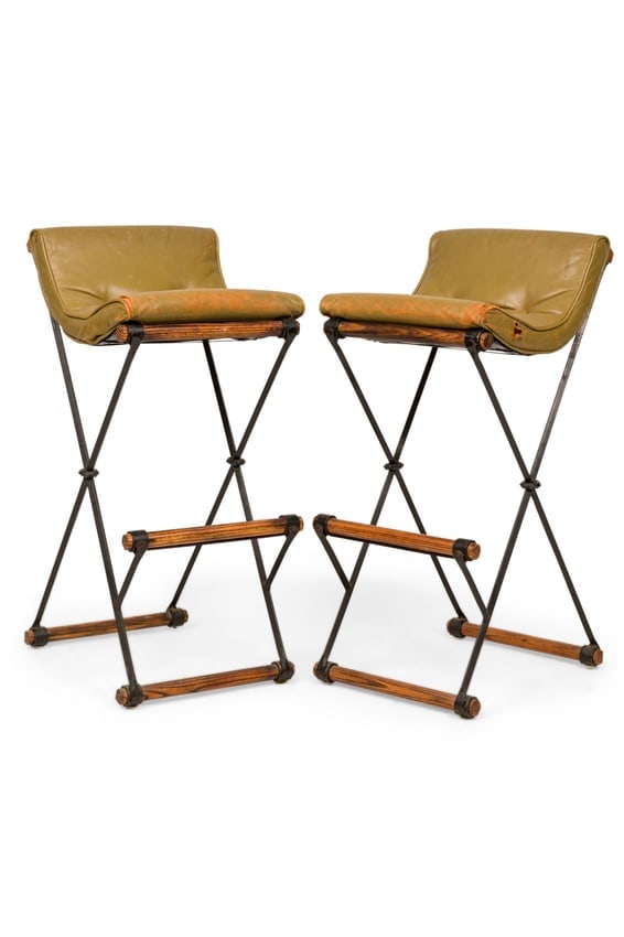 Pair of Cleo Baldon Mid-Century X-Frame Bar Stools: c. 1970s, USA, the avocado green leather button tufted seats on sturdy iron and oak frames, for Terra of California, 16"l x 19"d x 37"h, 30"sh