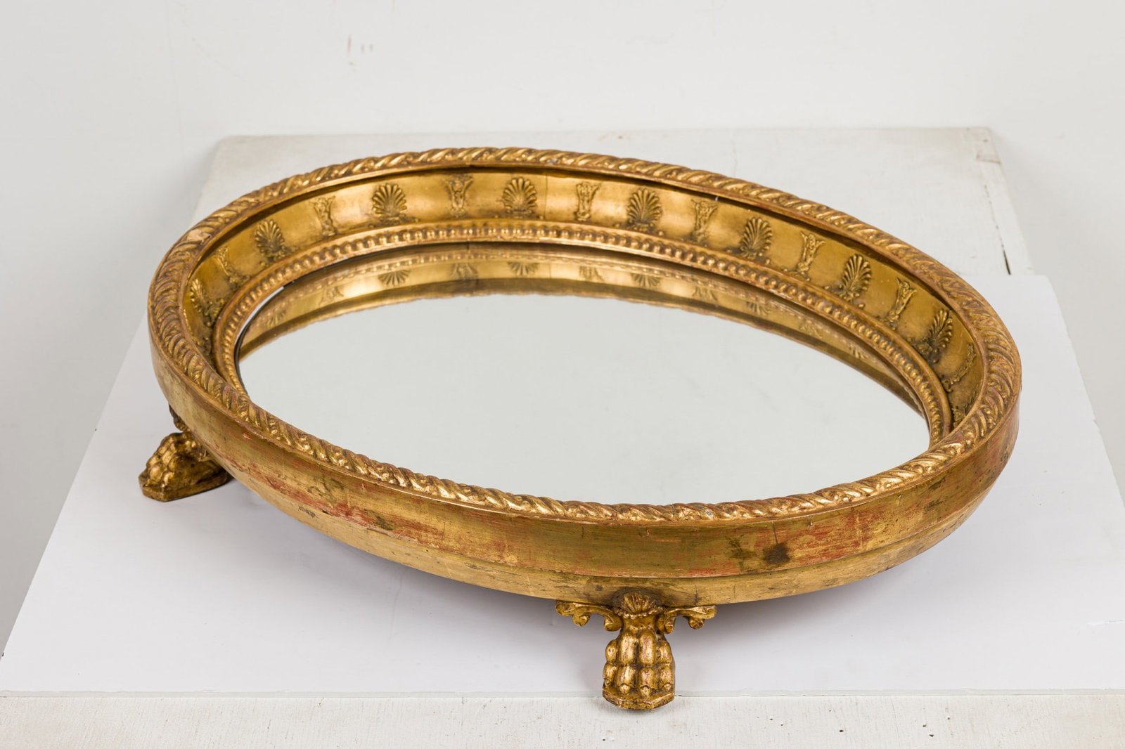 Louis XV style giltwood oval surtout de table: 19th c., Continental, the oval frame carved with acanthus, gadrooned rim, mirrored bottom, raised on paw feet, 4"h x 23"l x 18"w Provenance: Property from the Collection of Scott Snyder