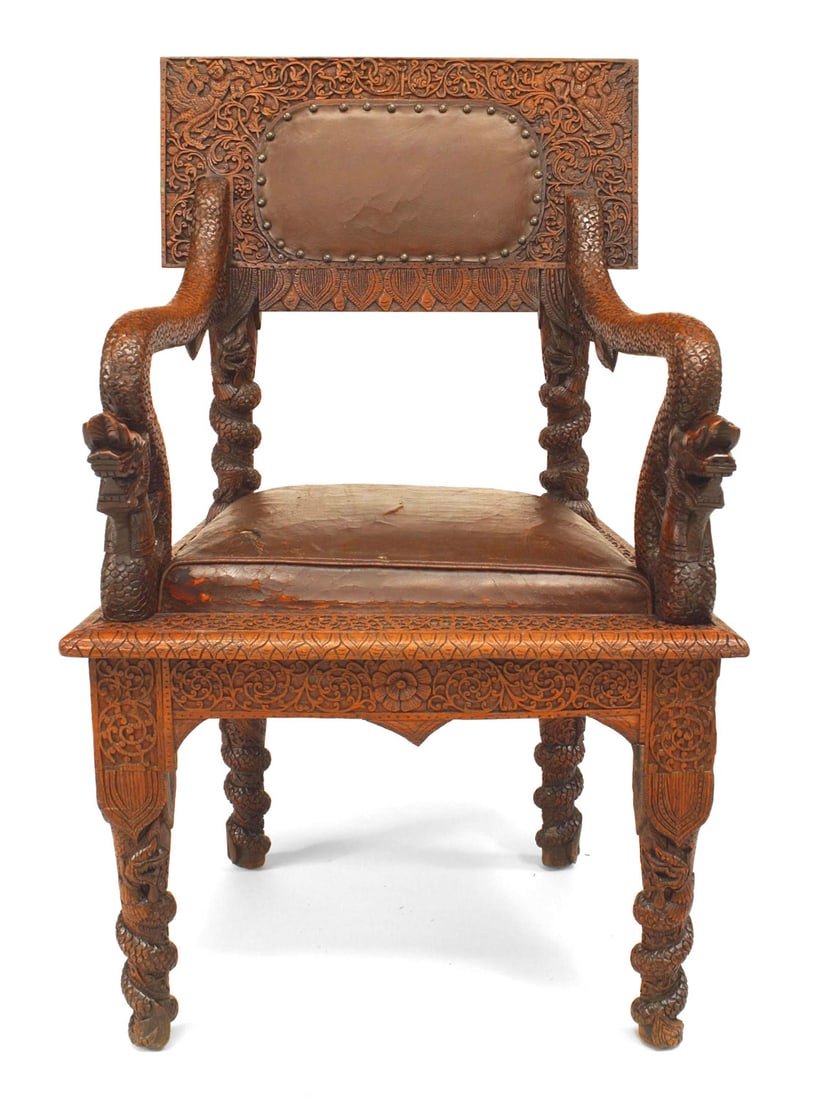 Burmese Carved Oak and Leather Armchair: Asian Burmese-style (19th Century) carved oak armchair with decorative arms and brown leather upholstered seats and backs.Dimensions: 25.5"w x 22"d x 40"h, 20"sh
