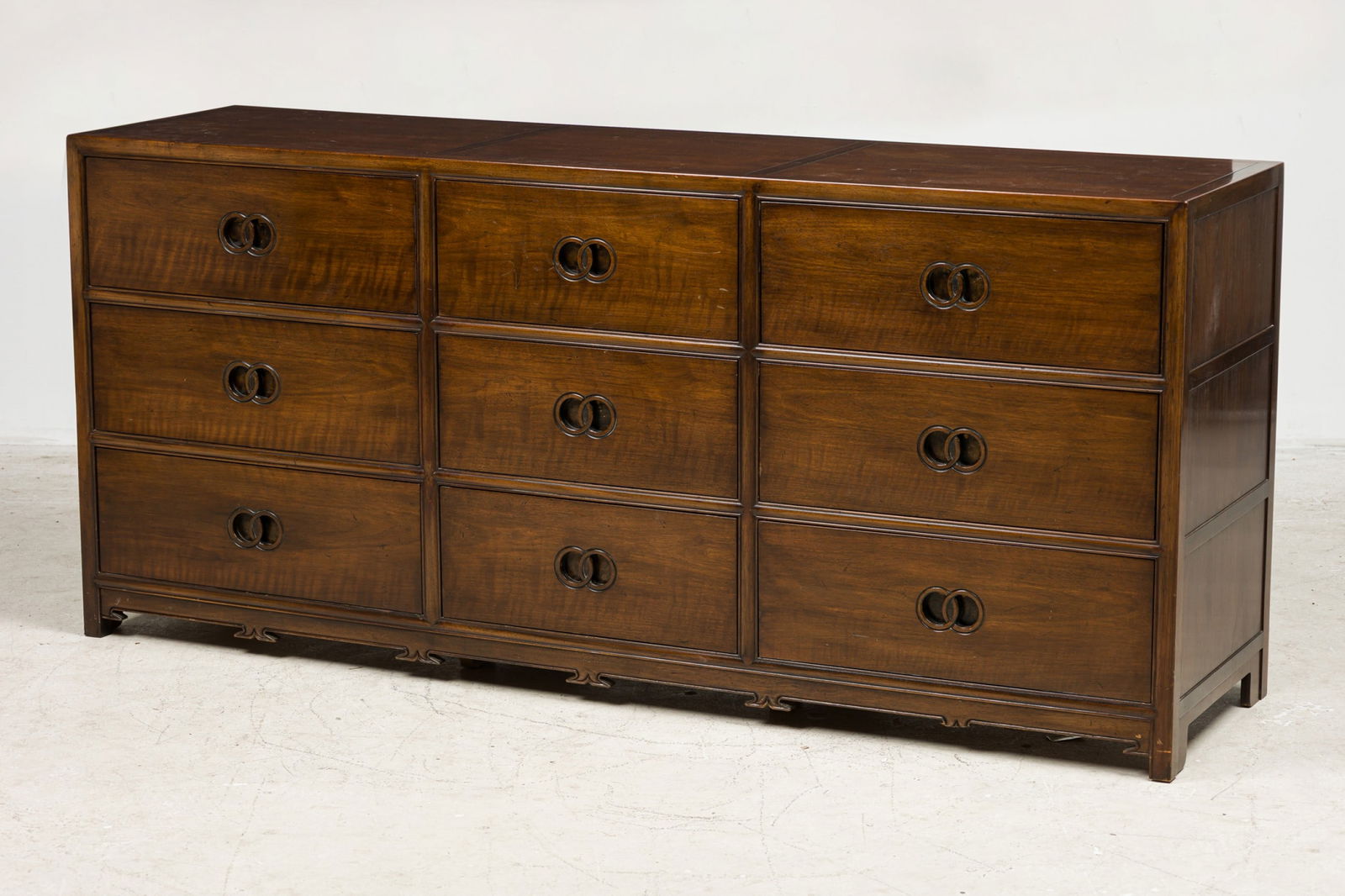 Michael Taylor For Baker, "Far East" Dresser: c. 1960, USA, mahogany, nine drawers, each with carved double-ring pull, Baker Furniture label on inside drawer, 32"h x 71.5"l x 19"d Provenance: Property from a Tommi Parzinger Furnished Home, Westfi
