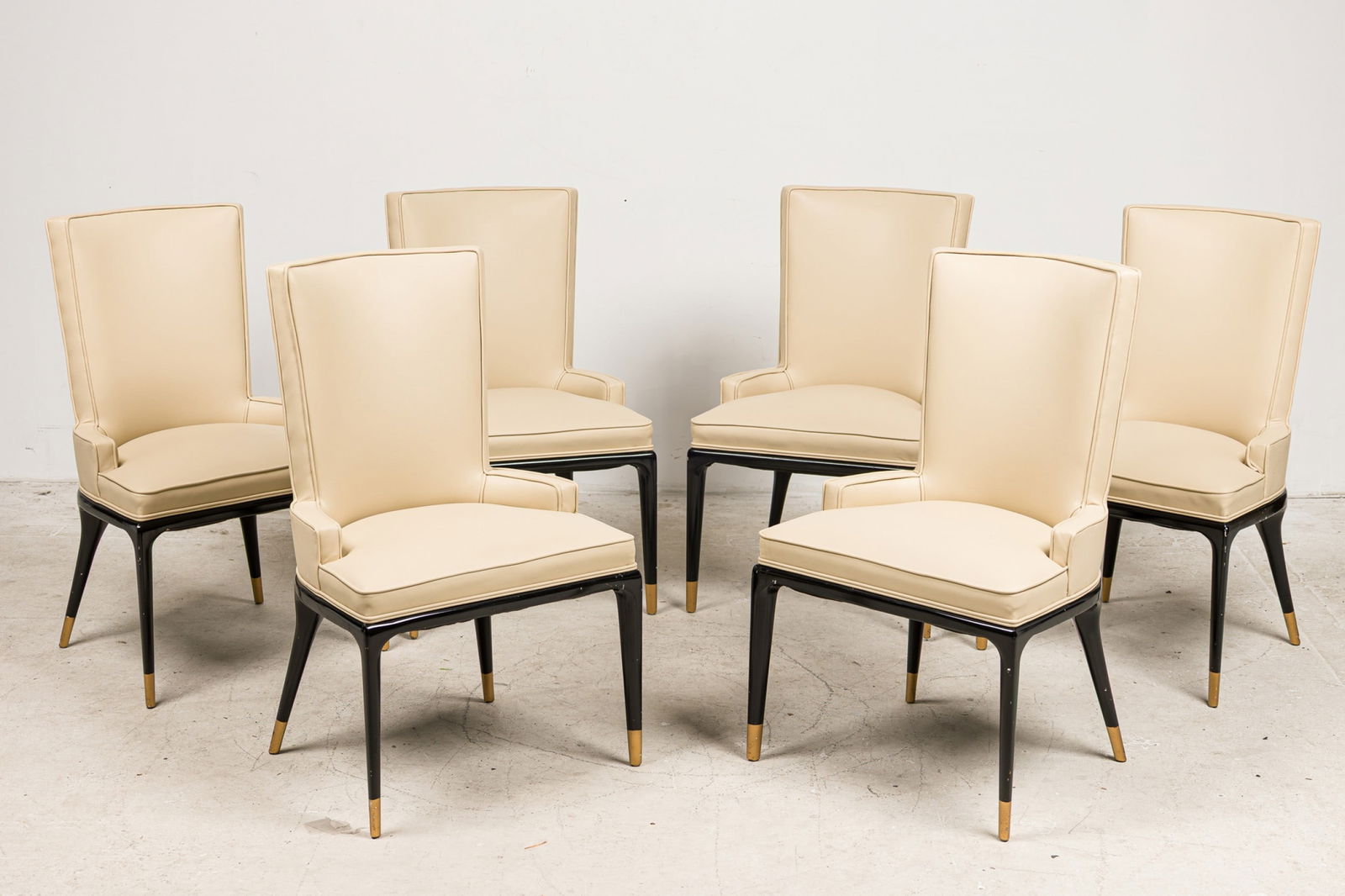 Tommi Parzinger, (6) Tailored Dining Chairs: c. 1960, USA, black lacquered wood, painted feet, tan leatherette upholstery, in a tailored profile with half-height arms and splayed legs, for Parzinger Originals ,37"h x 23"w x 18"d, 18"h (to seat)