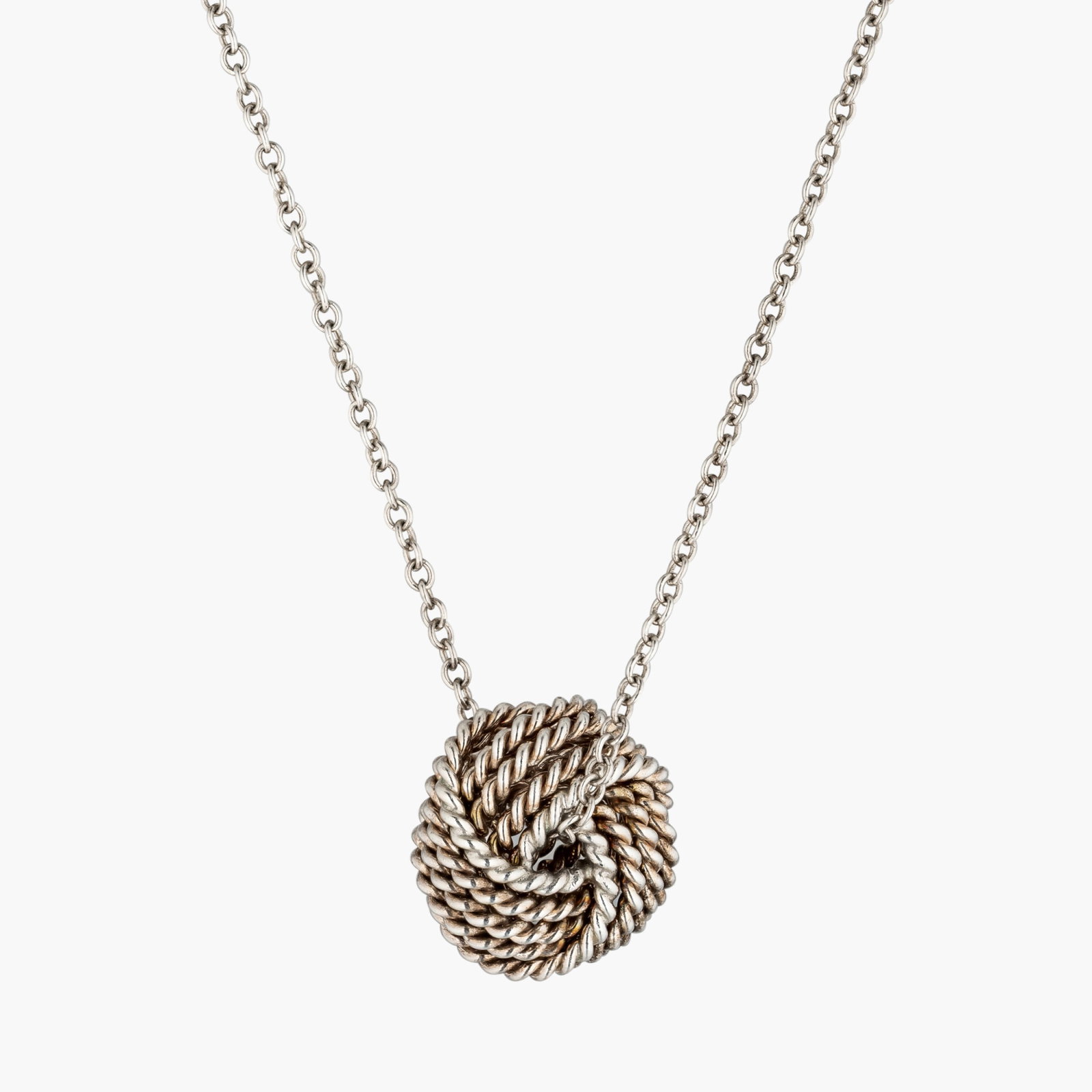 Silver Knot Pendant And Chain By Tiffany & Co.: Origin: Contemporary Metal: Silver Measurements : 16 inches long Weight: 2.3 g Sign: Tiffany&Co. Condition: In excellent conditionbs. The absence of a condition report does