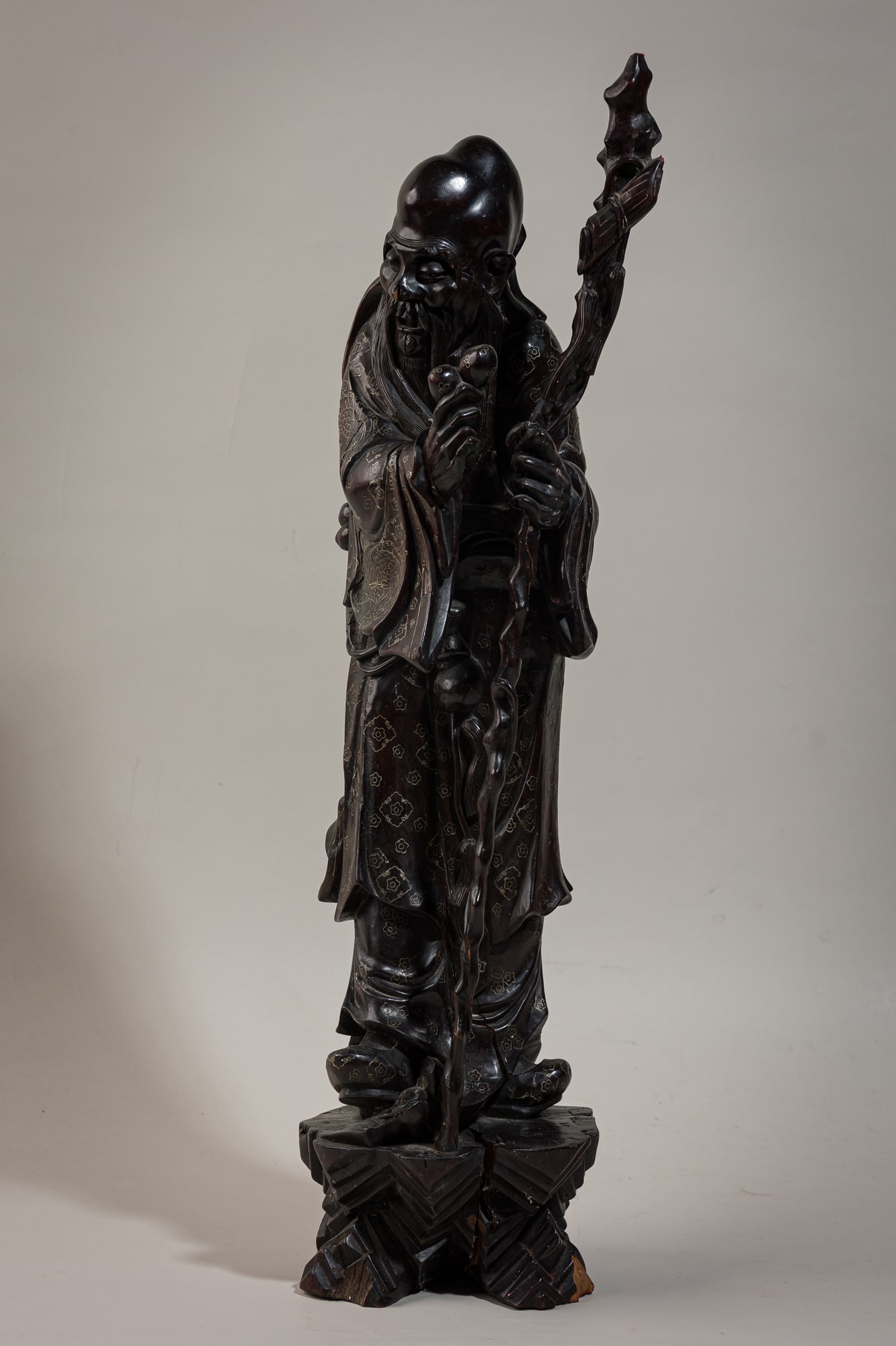 Japanese hardwood carving of Shou-Lao: Late Meiji Era (early 20th c.), Japan, possibly boxwood, modeled holding a staff and a gourd, wearing elaborately decorated robes, 25"h x 7"dia Provenance:Property from a Tommi Parzinger Fur