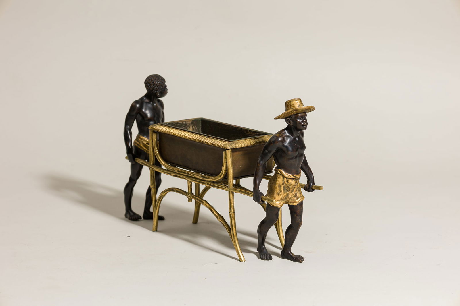 Napoleon III Parcel Gilt Bronze Figural Jardiniere: second half 19th c., France, modeled as two blackamoor figures carrying and open chest mounted with bamboo staves, 7.5"h x 13"w x 3.5"d Keywords: Bronze & Busts, Bronzes, Decorative Arts, Europe, Meta