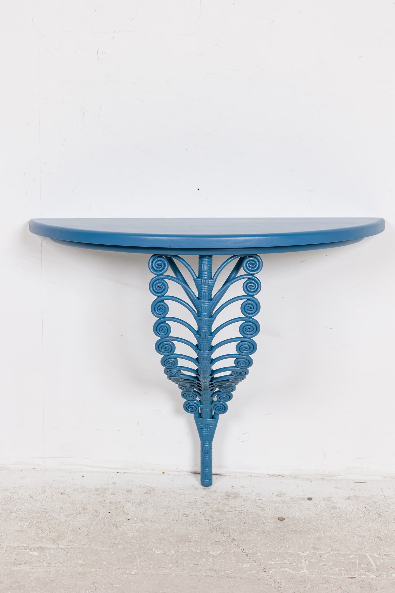 Soane Britain, Rattan Fern Console: 21st C., England, cerulean blue painted wood and rattan, the demilune top over fiddlehead twist support, wall-mounting, makers medallion to underside, 31"h x 36"w x 17"d Provenance: Mod