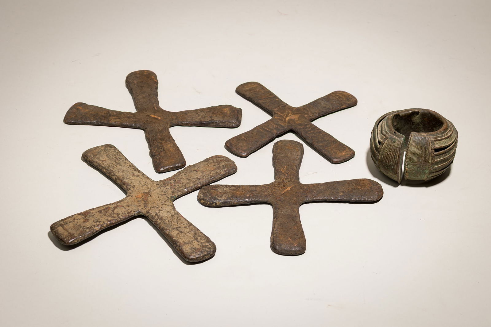(4) Katanga bronze currency crosses and cuff, ex-Allan Stone: 19th/20th c.,Democratic Republic of Congo, slightly flaring arms, gallery label tags, 8.5"h x 8.5"w (each), together with, 19th/20th c., Baule bronze currency anklet with intricate circle mo