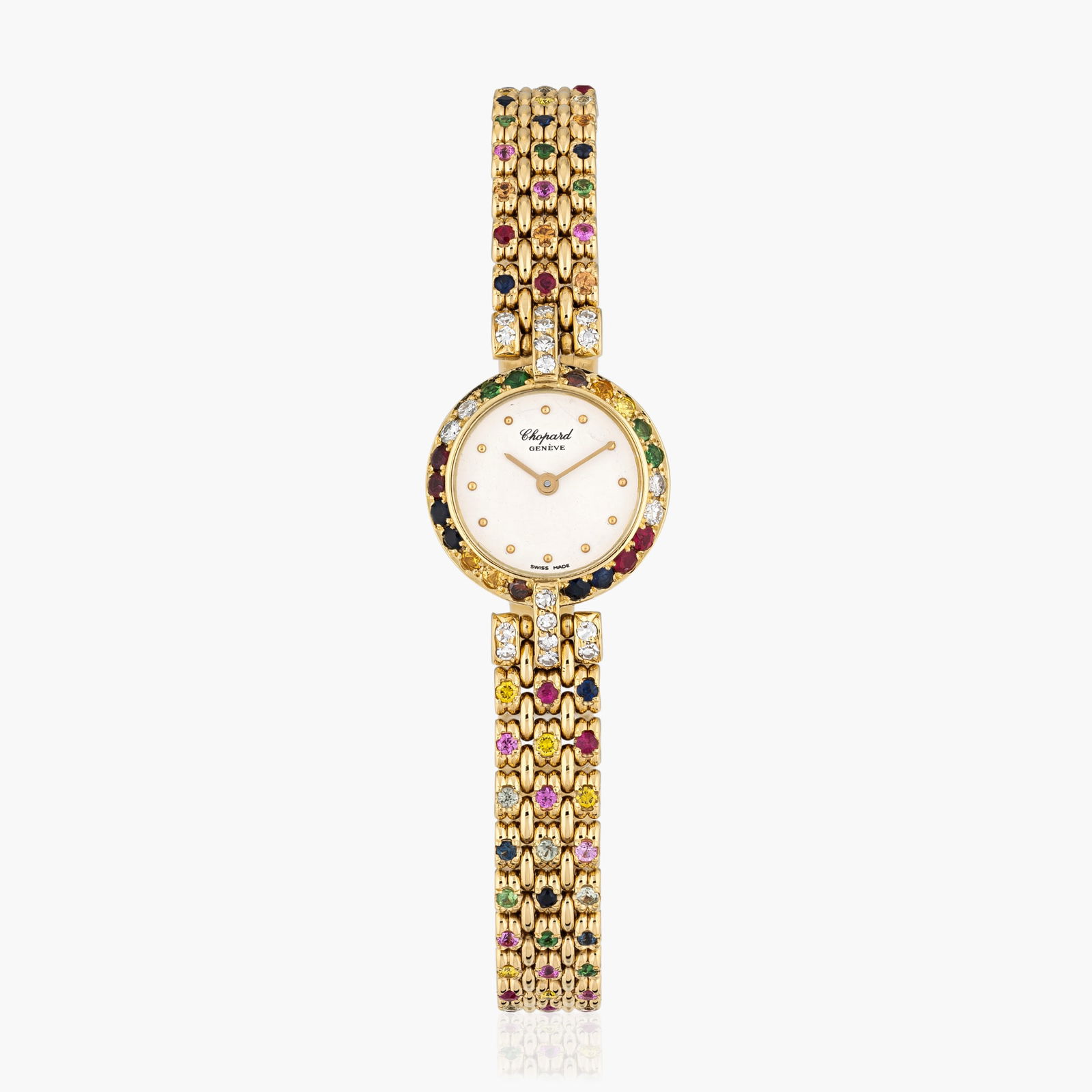 Chopard Ladies Watch In 18K Yellow Gold With Colored Stones: Circa: 1980sDial: Matte white dial with applied hour markersCase material: 18K yellow gold with colored stonesBracelet material: Original integrated bracelet in 18K yellow gold with colored