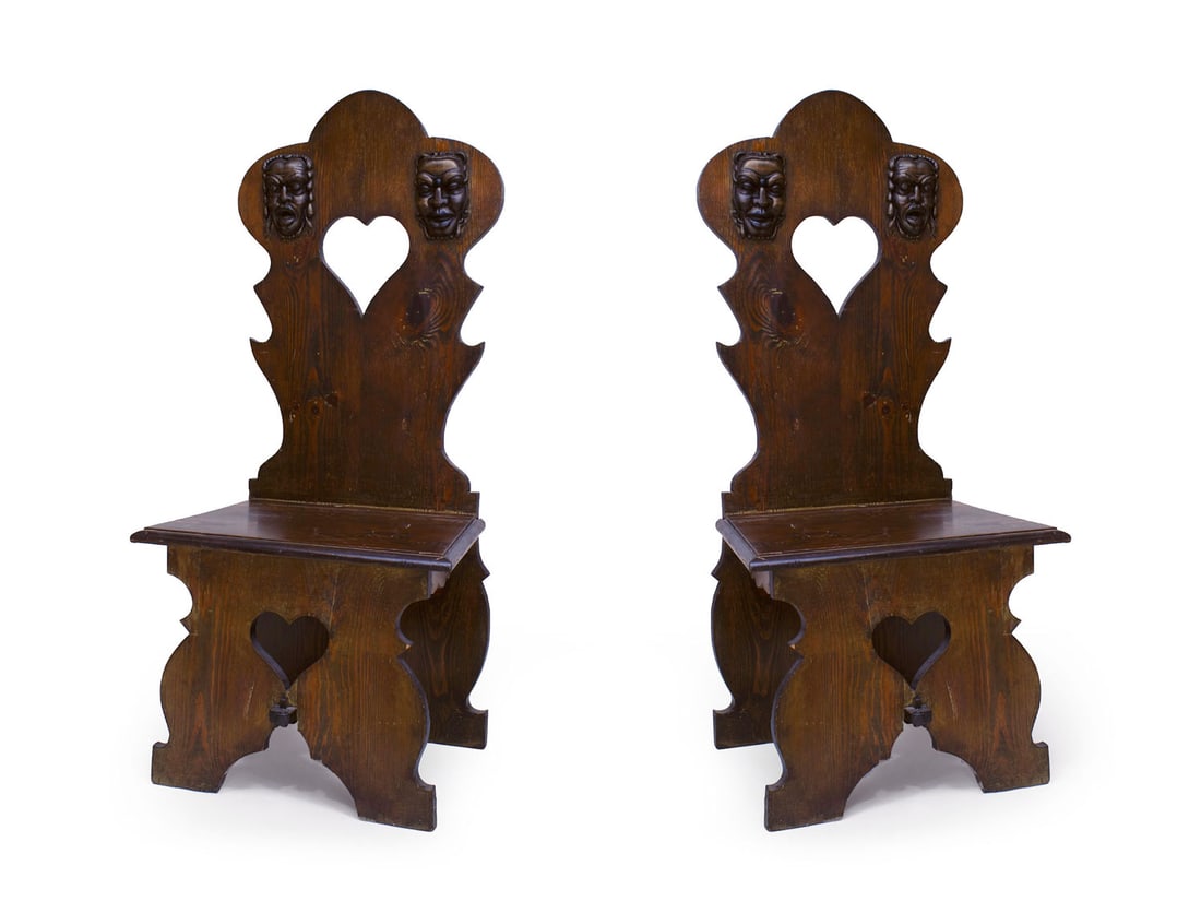 Pair Italian Renaissance Revival Pine Sgabello chairs: 20th c., the shaped backsplate with heart-shaped carve out flanked by carved masks, conforming front support, joined by plank set, possibly Venetian carnival watching chairs,46"h x 17"w x 21"d