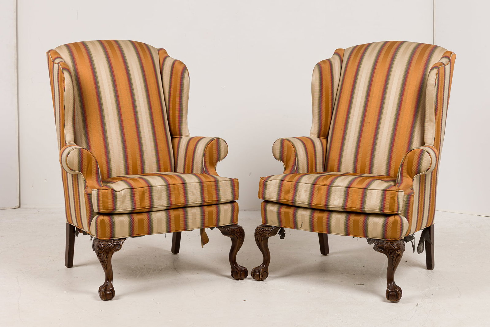 Pair George III style wingback chairs: 20th c., upholstered in a multi-color striped fabric, raised on carved wood legs ending ing claw and ball feet, Fairfield Chair Co. label to decking, 45"h x 27"w x 28"d, 20"h (to seat)Provenance: 465 