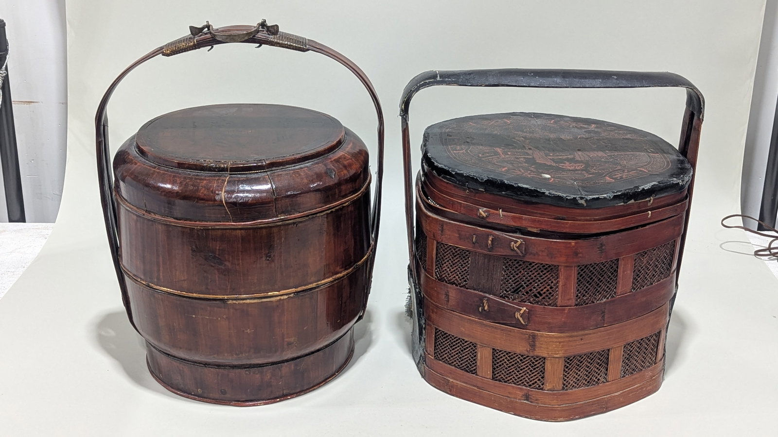 (2) Chinese Lacquered Bamboo Dowry Basket: Late Qing or later (19th/20th c.), black and red stained bamboo slats, both with arch handle, lid, opening to storage, one with Chinese inscription on the side, each approx 21"h x 16"diaProvenance: Fr