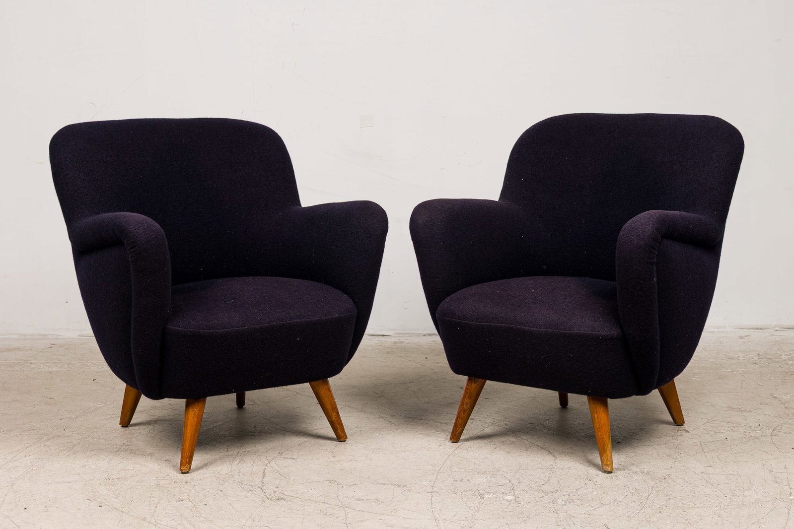 Nice Pair Vintage Modern Club Chairs: c. 1950s, likely Swedish or Italian, fully upholstered dark blue wool seat, raised on round tapering legs, unmarked, 34"h x 28.5"w x 23.5"d, 17"h (to seat)Provenance: Modern Design from a Private Coll