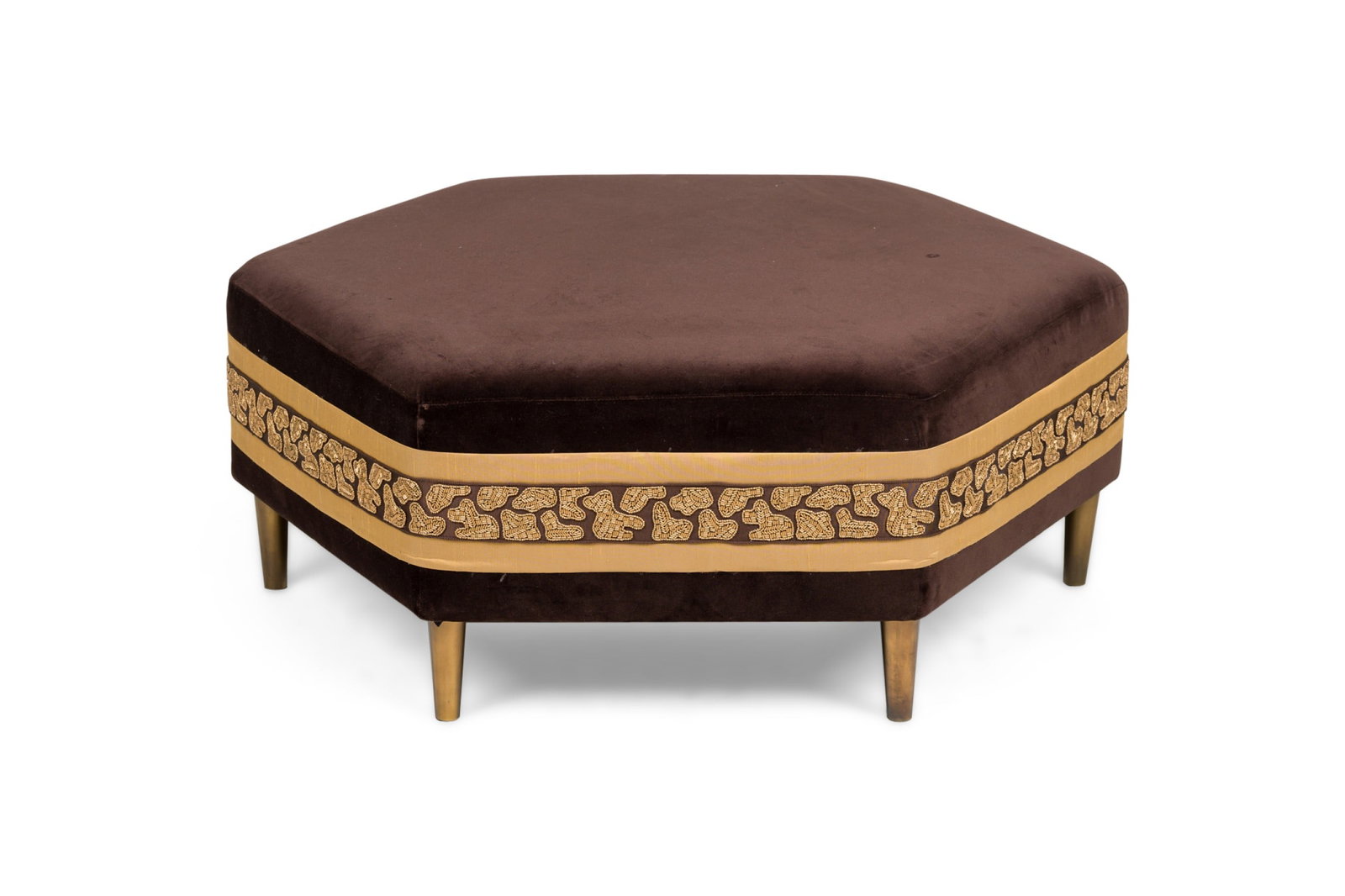 Contemporary brown velvet hexagonal ottoman: 21st c., USA, hexagonal frame, upholstered in brown velvet with a decorative gold stripe with beaded shapes around the sides, resting on 6 tapered brass toned legs, 15.5"h x 35"w x 39"d