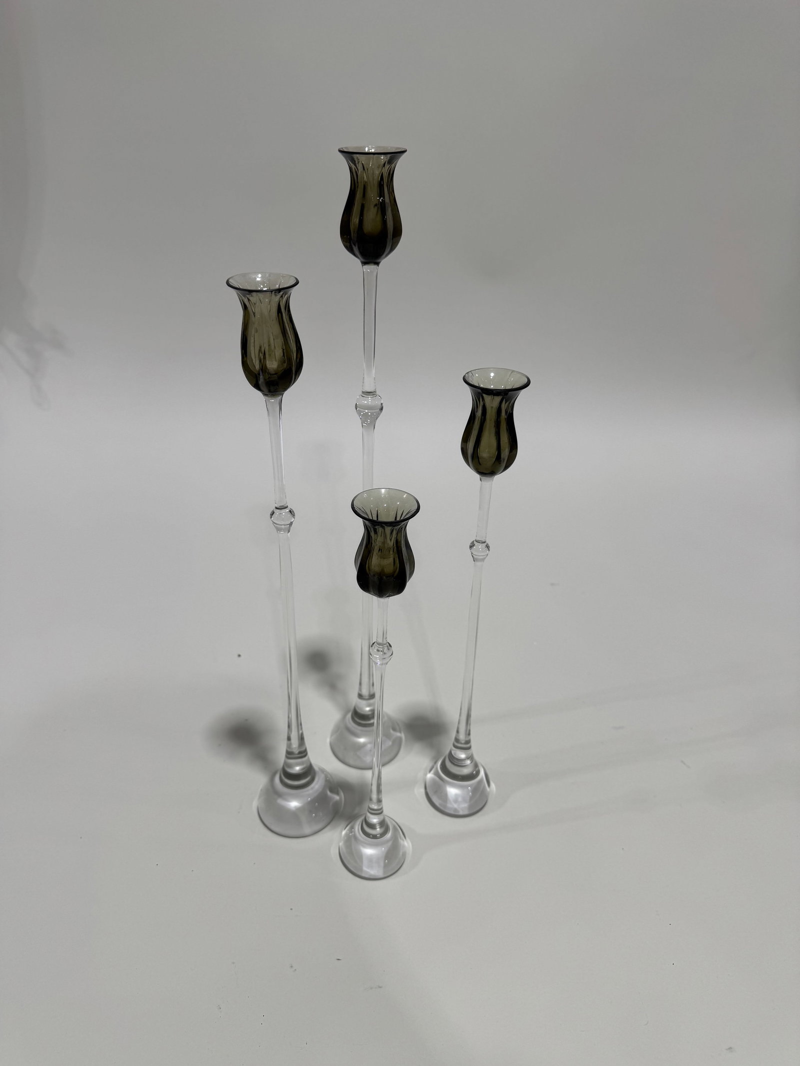 Bjorn Wiinblad, (4) "Tulipa" crystal candlestick holders: 20th c., Denmark, hand blown glass, the smoky glass tulip cup on slender pedestal with spreading foot, for Rosenthal Studio Line Germany, 20.5"h (tallest)Provenance: From a Mac II decorated home: 465 