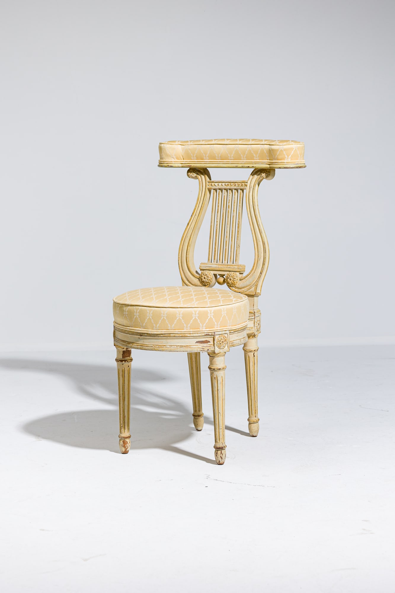 Louis XVI style painted voyeuse: c. 19th c, France, cream painted carved wood frame, with lyre-form back, raised on round channeled legs, the padded crest rail and round seat upholstered in a silk damask, 36"h x 20"w x 18&q