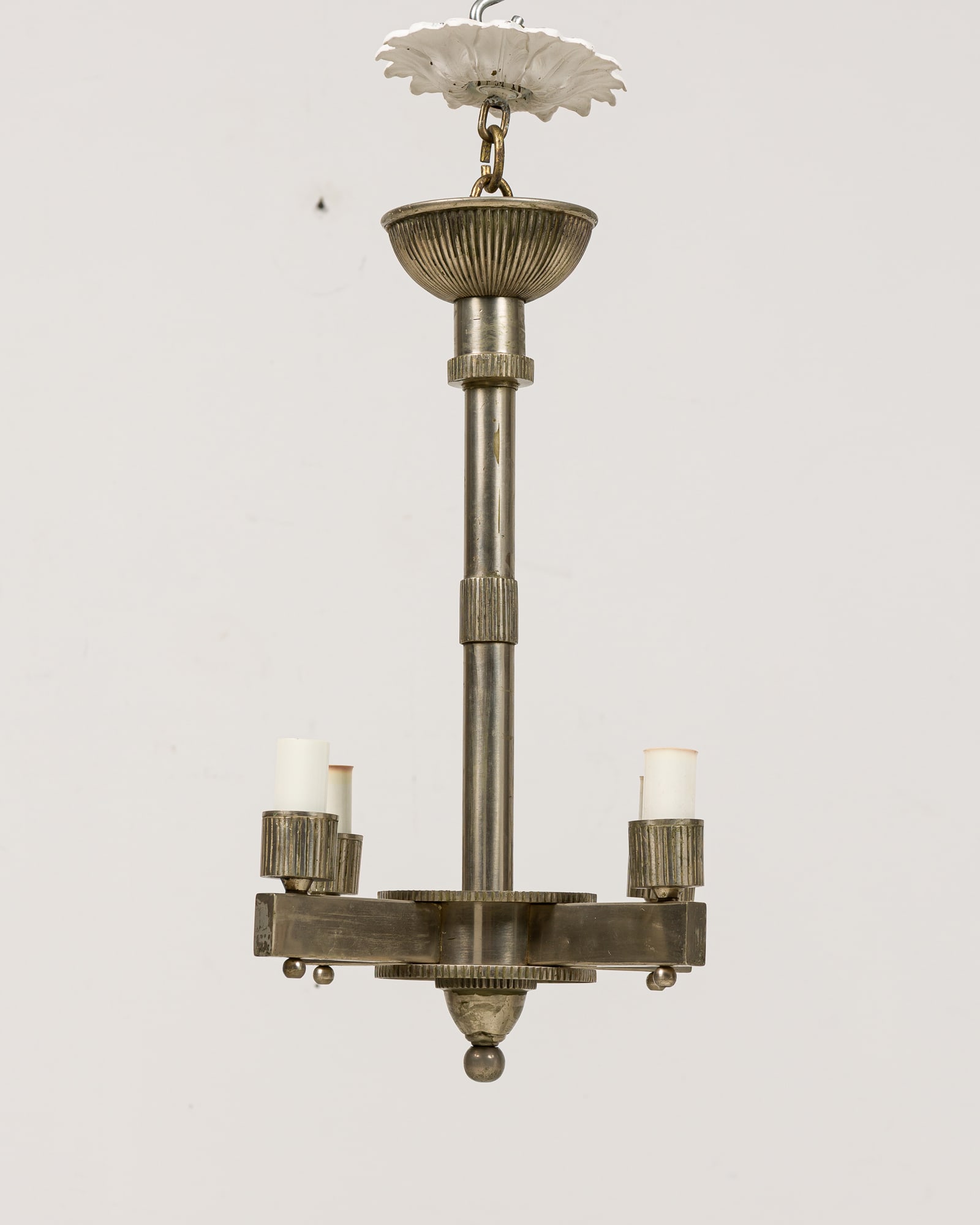 Art Deco nickel-plated chandelier: c. 1930s, France, nickel-plated finish, stem with geometric stepped design, four arms each with ribbed cylindrical cups supporting white socket covers, "x" stamped inside canopy, 26"h x