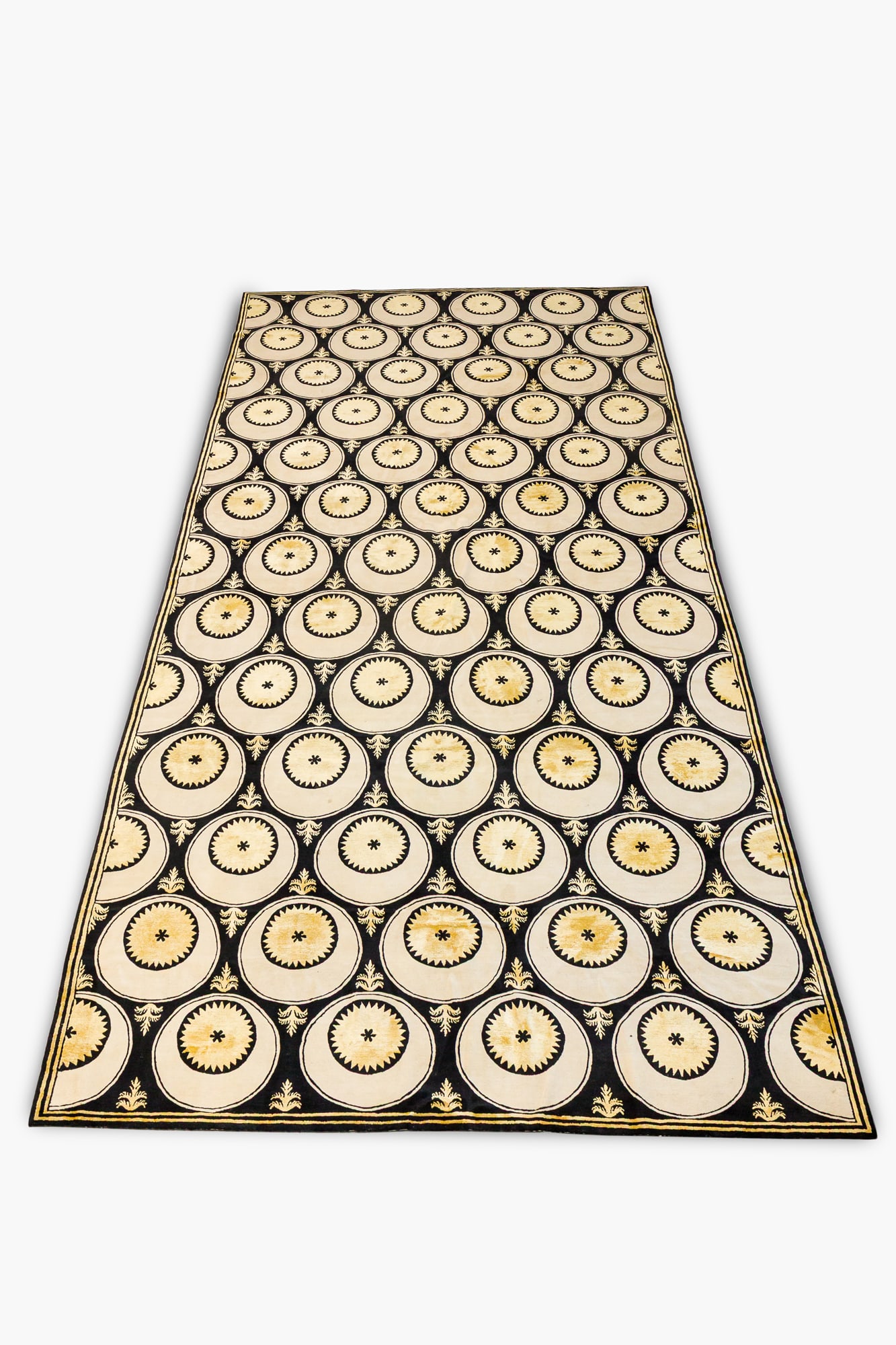 Doris Leslie Blau, custom palatial geometric carpet: 20th/21st c., Nepal, hand-woven knotted short pile yellow, black, and cream wool, with rows of intricate circular sun panels interspersed with foliated fleur de lis, approx 21' l x