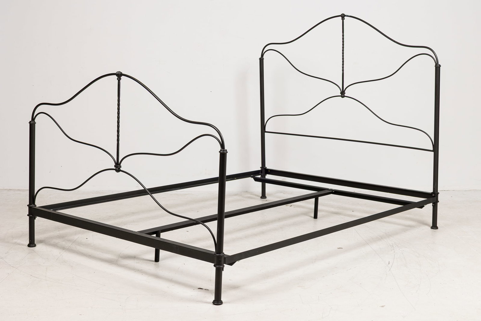 Charles P. Rogers 'Provence' queen size bed frame, Thierry Despont: 20th c., USA, hand forged iron headboard and footboard with a quatrefoil design and black finish, heavy iron side rails, 56"h x 61.5"w x 84"d Provenance: Property from 850 5th Ave: